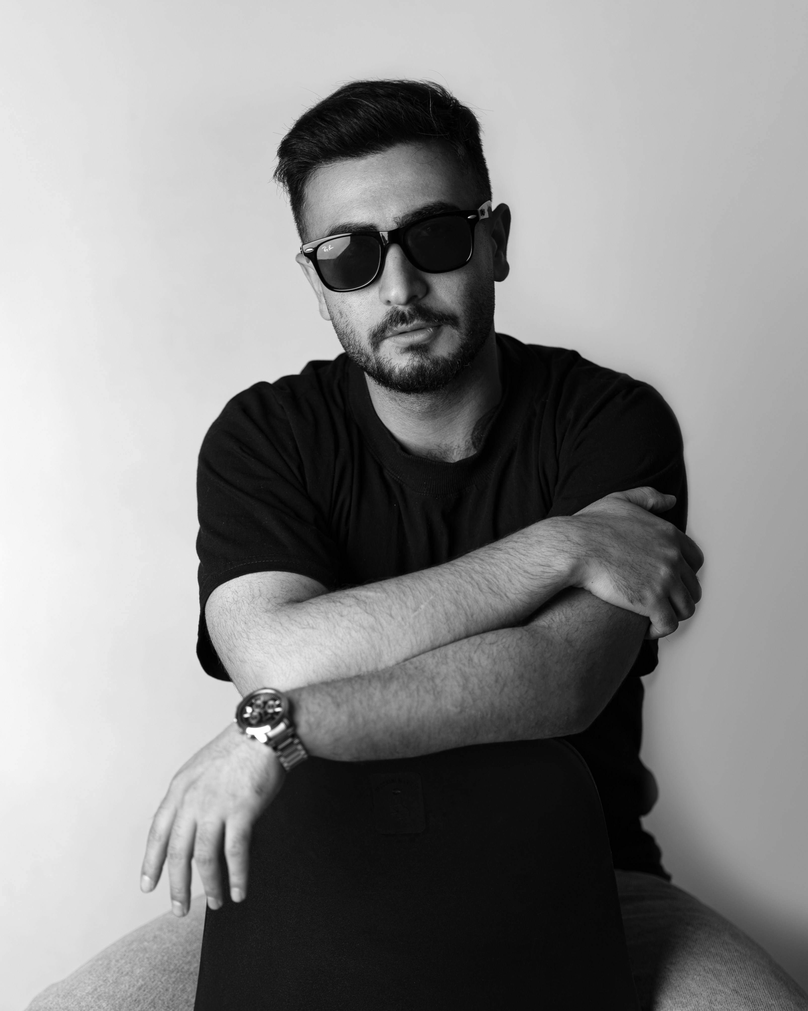 a man with his arms crossed sitting on a chair