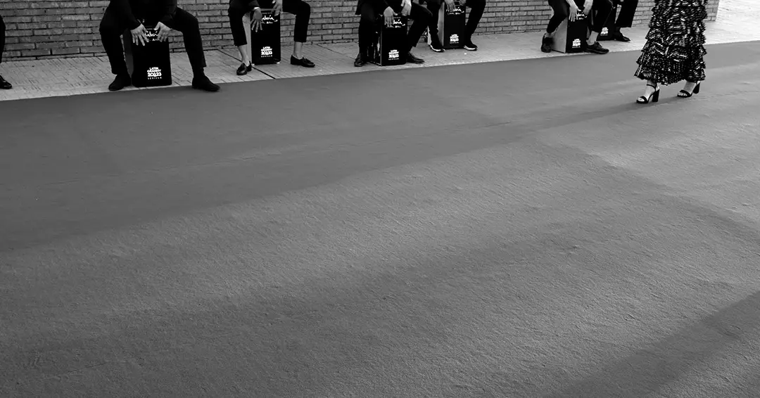 Solo se ven los pies de artistas tocando el cajon y flamenca pasando