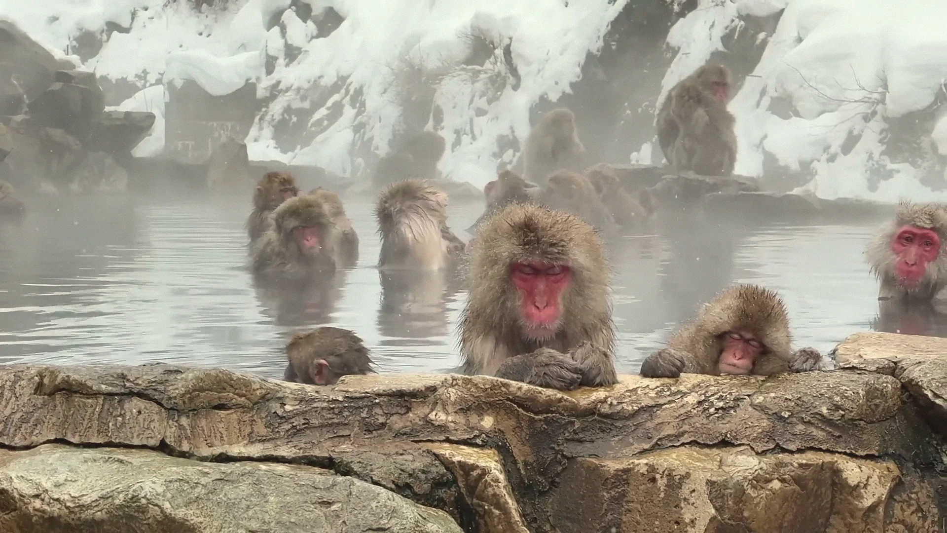 Outdoor ashiyu foot bath steaming in the snow at Yudanaka