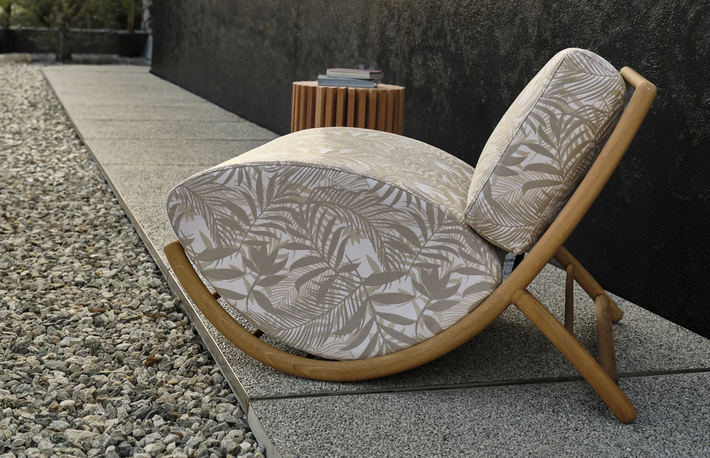 Luxury outdoor lounge setting featuring armchairs with solid Iroko wood frame and sculpted cushions, poolside in a modern villa with palm tree and designer side tables – elegant high-end furniture collection for refined outdoor living