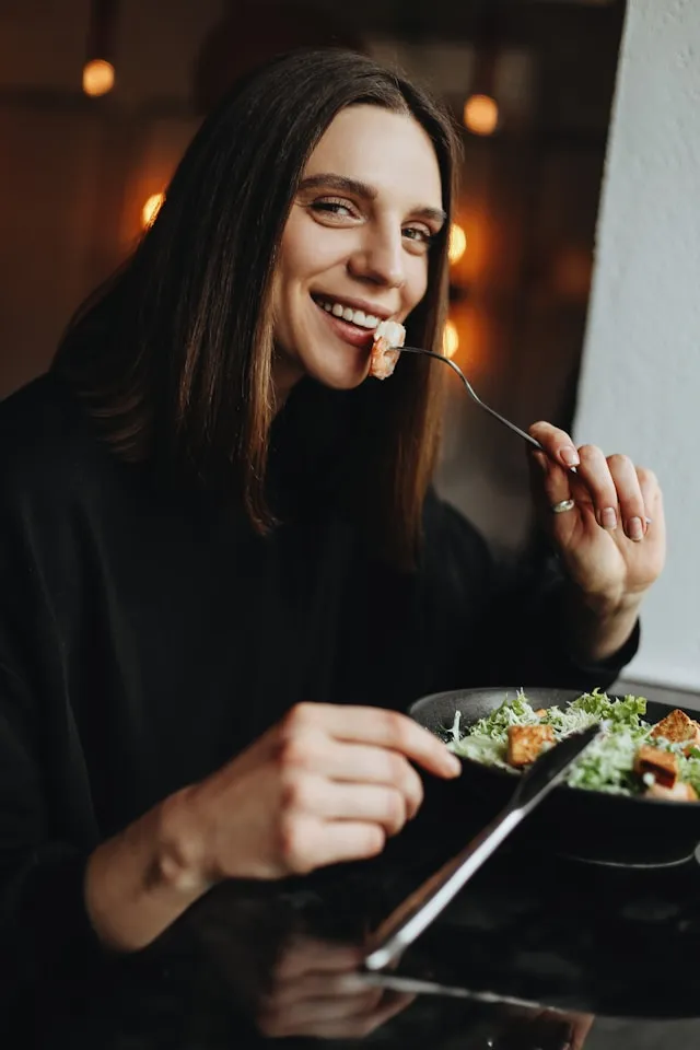 Woman eating dessert with a detailed nutrition summary card beside her