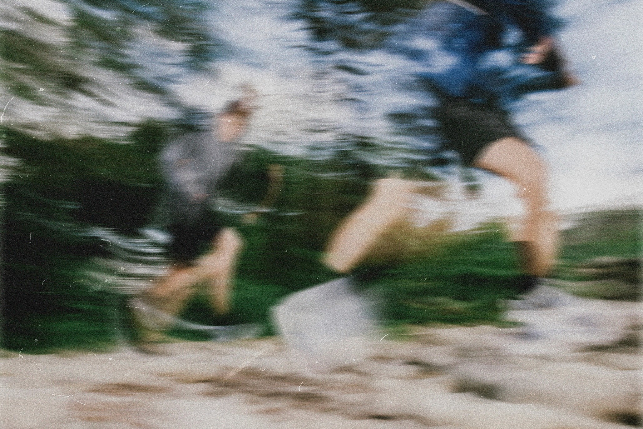 Young man with curly hair and headphones wearing a white jacket, flanked by prismatic ghosting effects and yellow flowers.