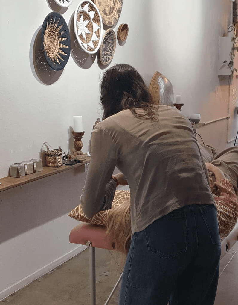 Woman meditates in lotus pose, wearing a rust-colored yoga set.