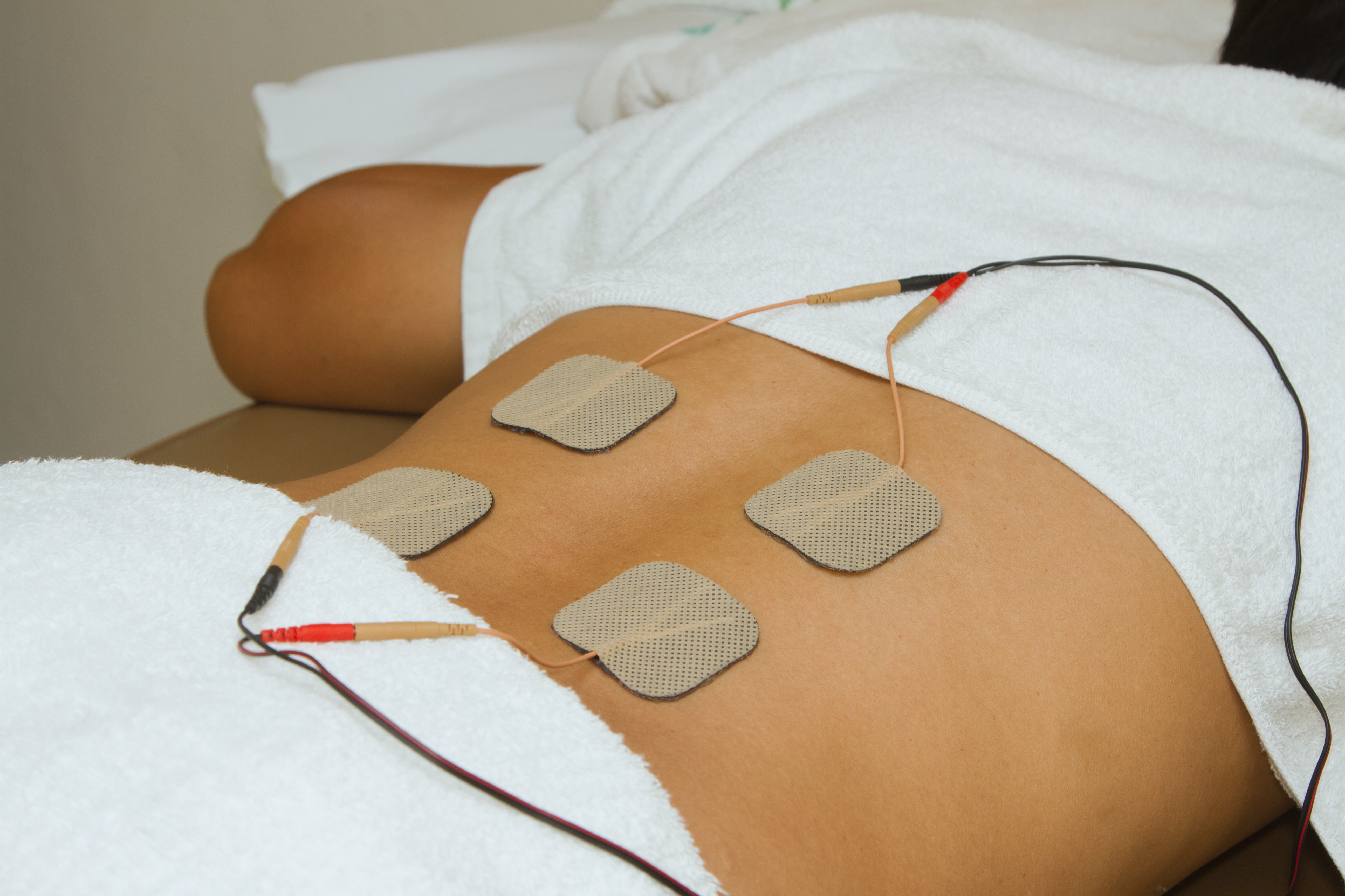 patient with electrode pads on lower back for EMS therapy
