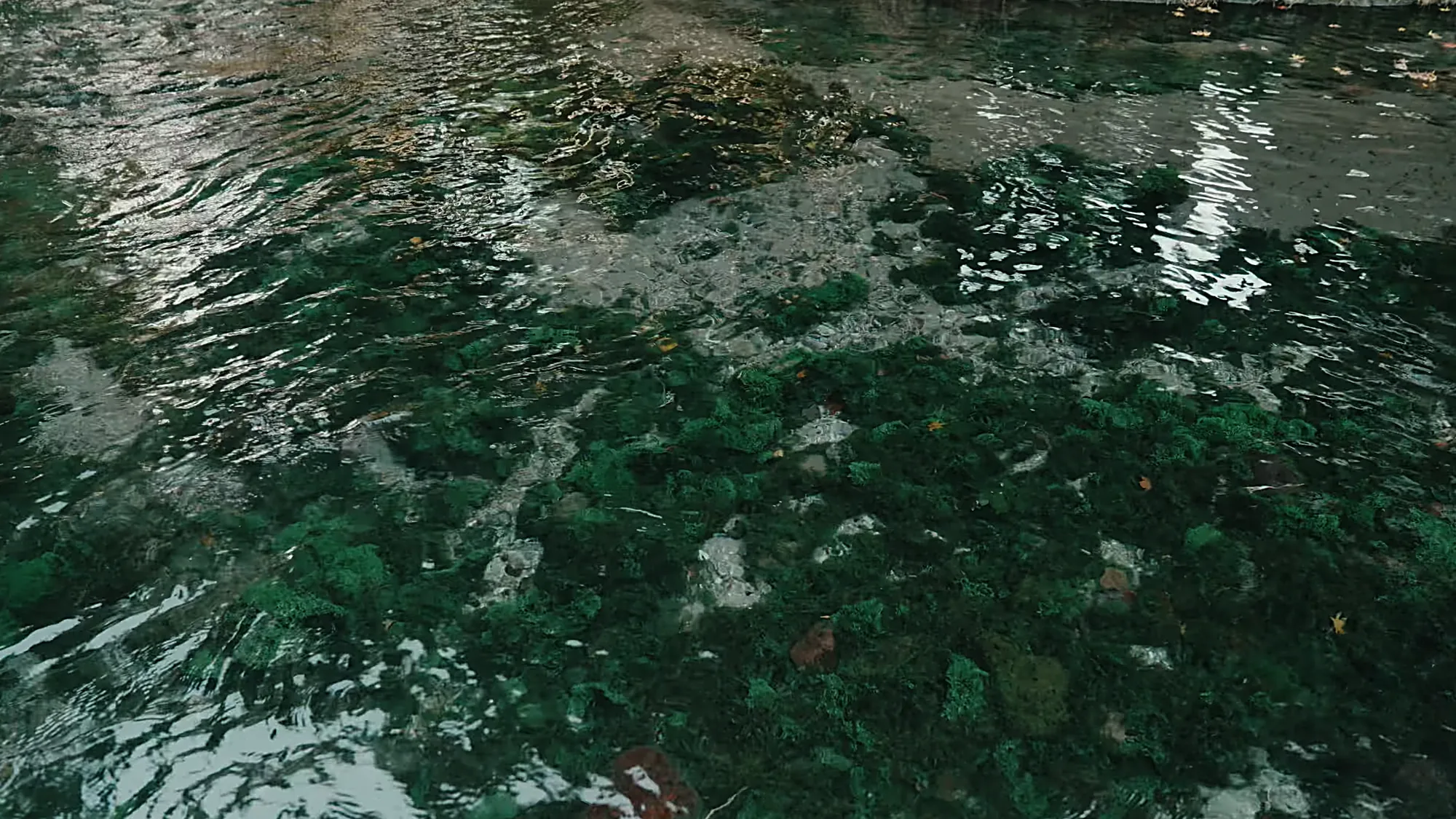 Clear green spring water running over stones near Kurokawa Onsen