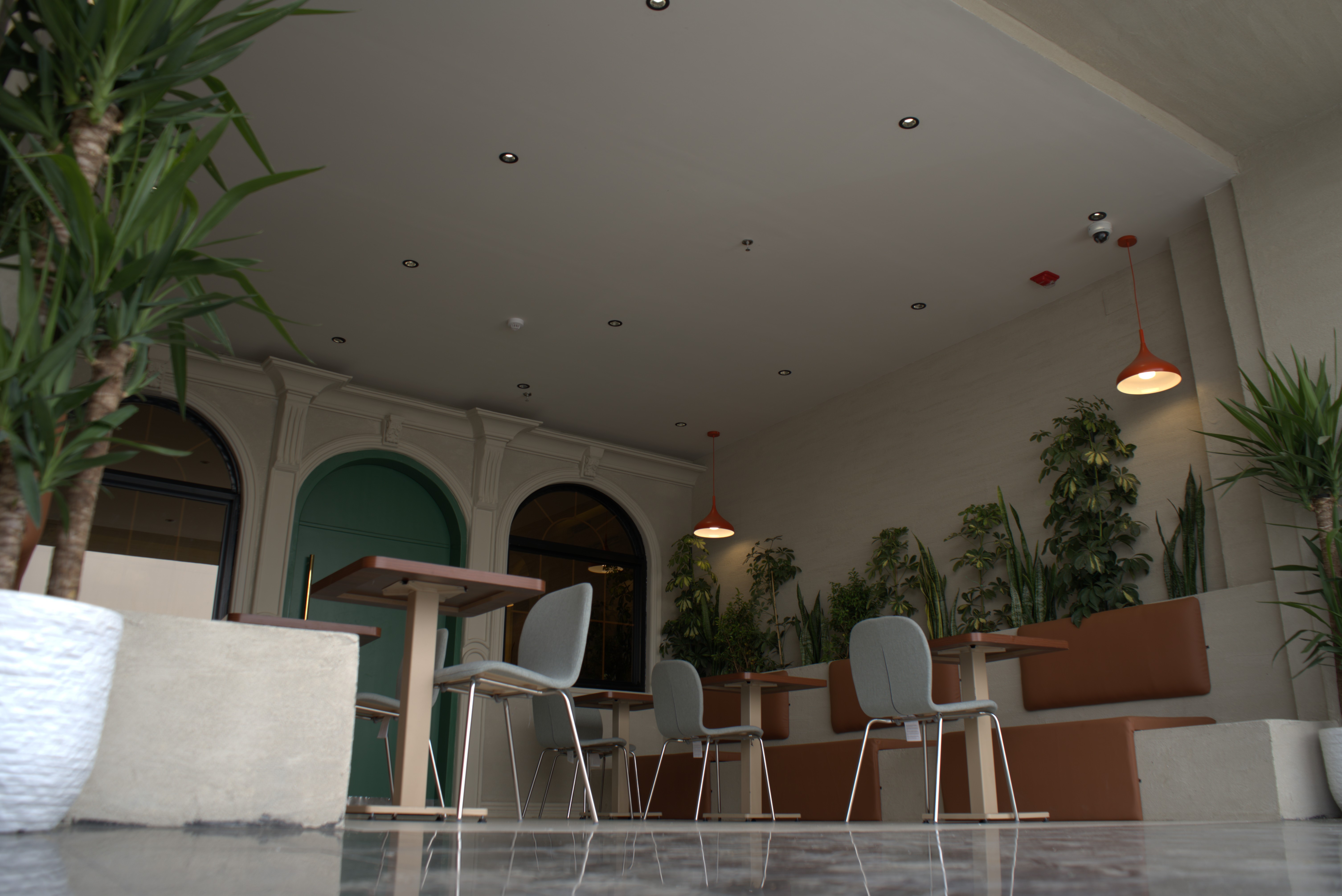 A luxurious indoor spa area with a pool, lounge beds, and a breathtaking view of a city skyline at sunset. The golden lighting enhances the warm and tranquil atmosphere, creating a perfect relaxation retreat.