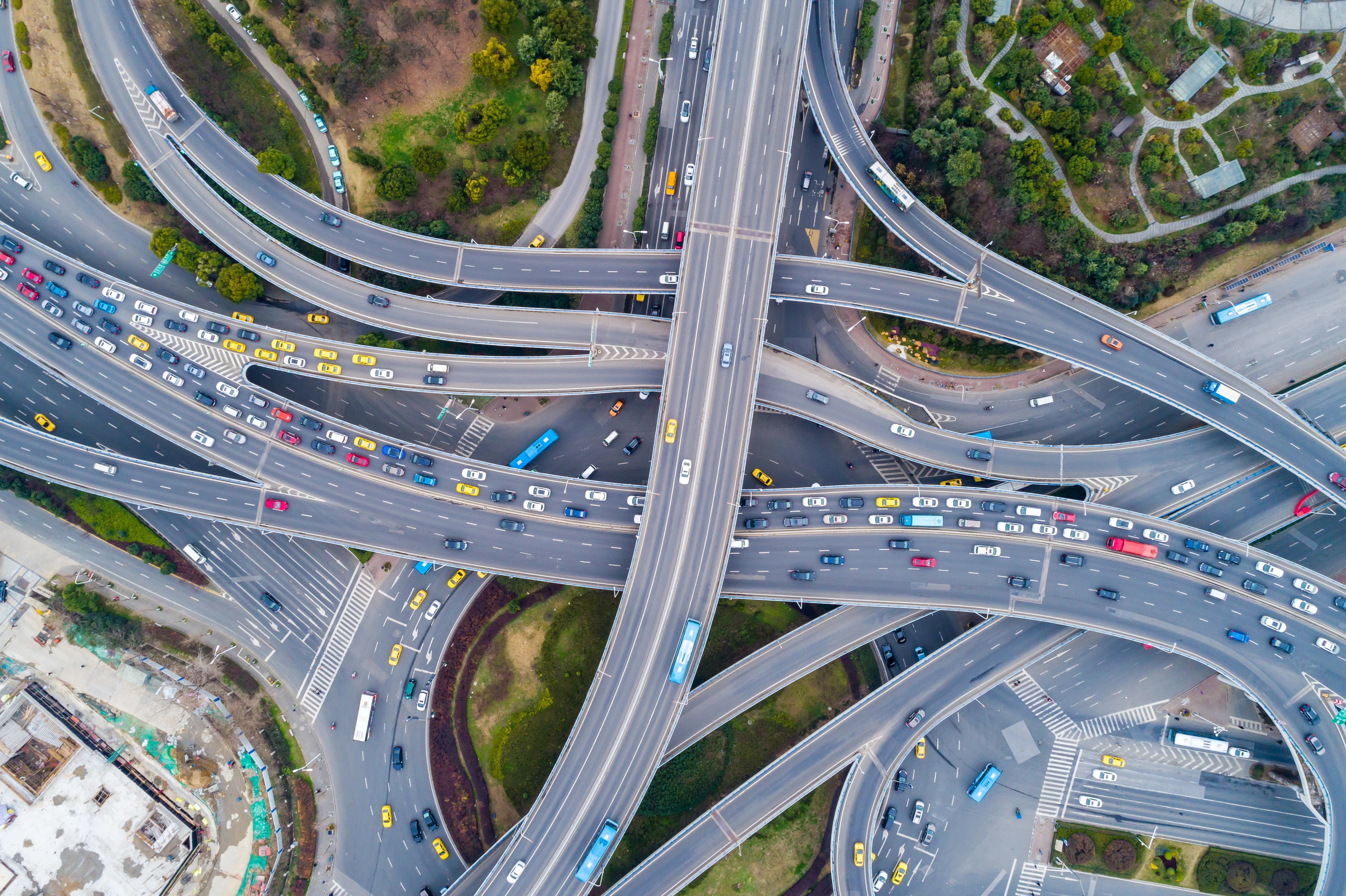 Aerial view of a complex highway intersection, showcasing multiple lanes and vehicles in motion from above.