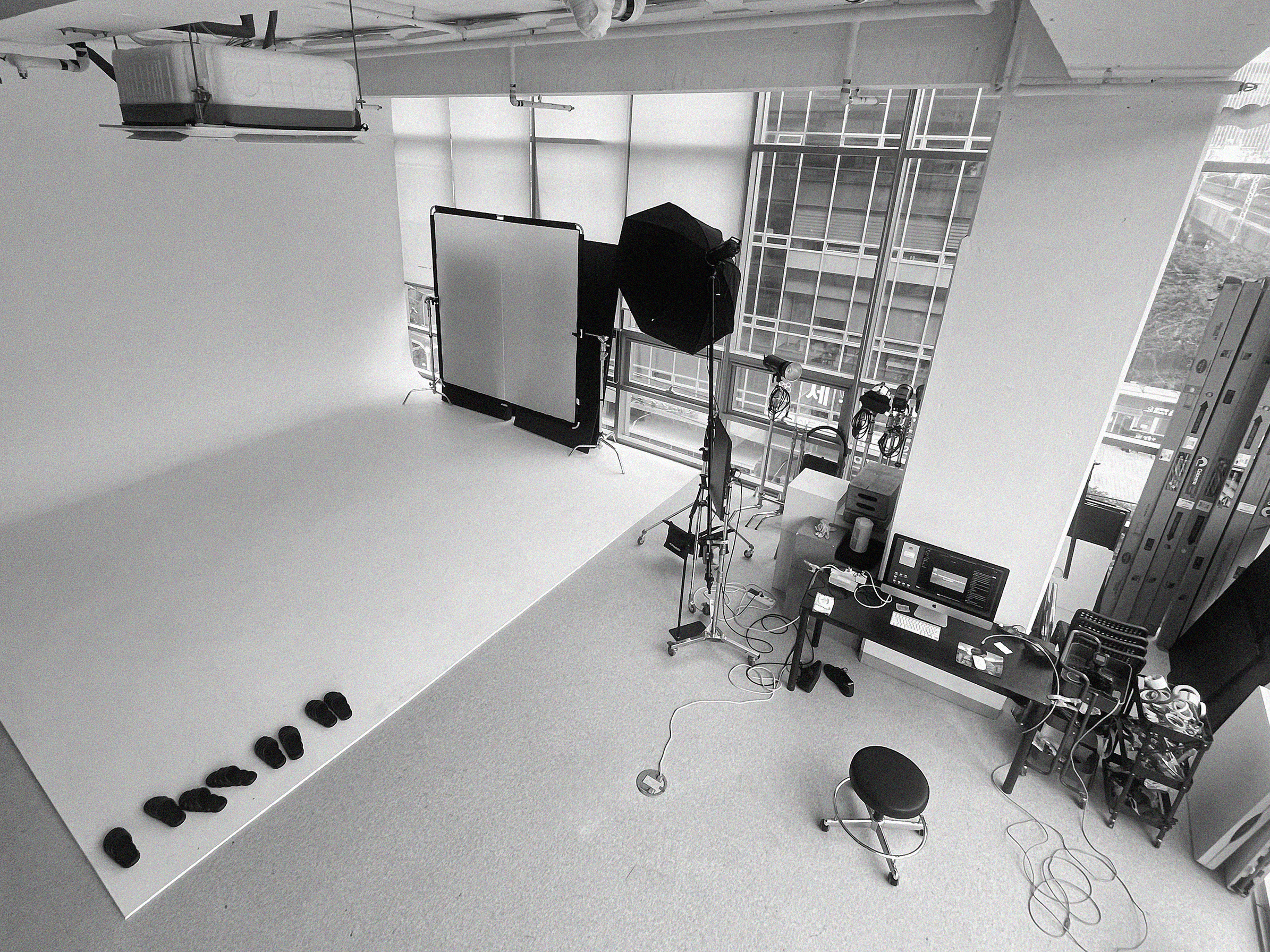 Modern red brick apartment or office building viewed from below against a blue sky, showcasing its geometric architecture with evenly spaced windows and balconies.