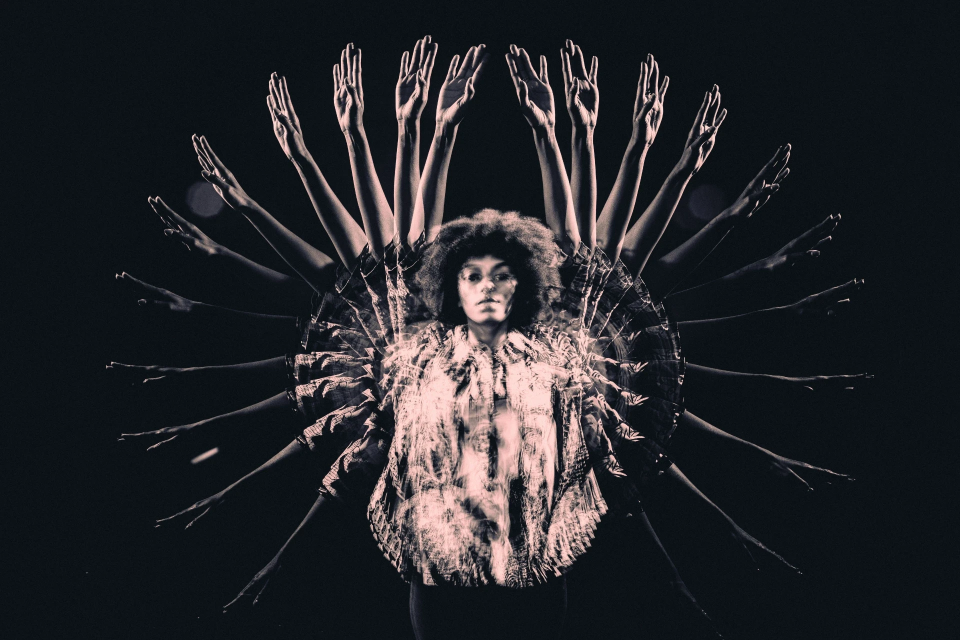 Überlagerte Silhouette einer Person mit vielfach ausgebreiteten Armen vor dunklem Hintergrund – visuelle Metapher für Teamarbeit, Vielfalt und gemeinsame Ausrichtung.