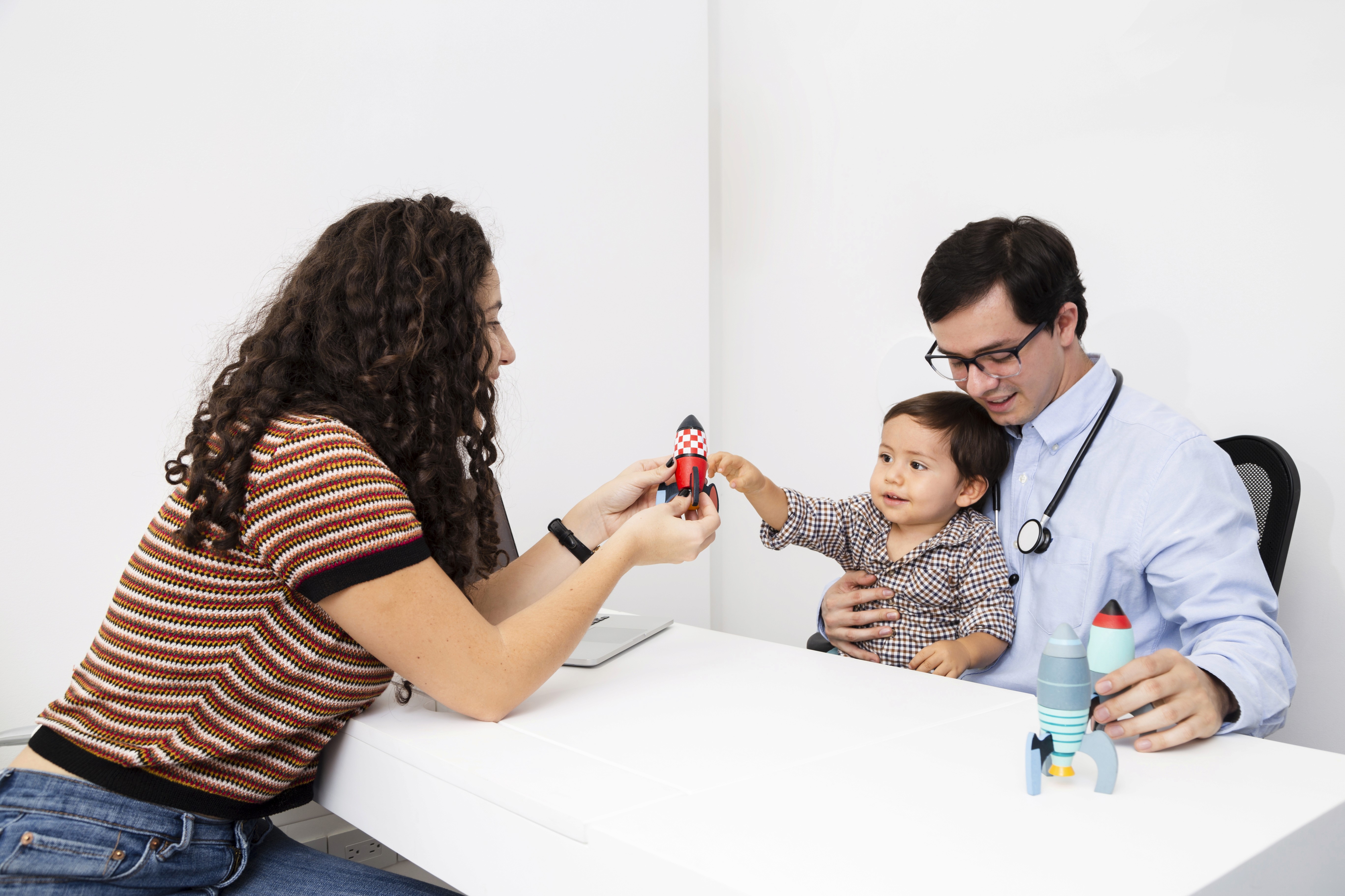 Doctor playing with the boy using toys to make him comforable.