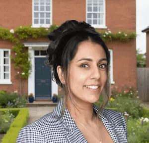 Professional photo of Reshma Thakore, woman with dark hair wearing light colored clothing, smiling at camera