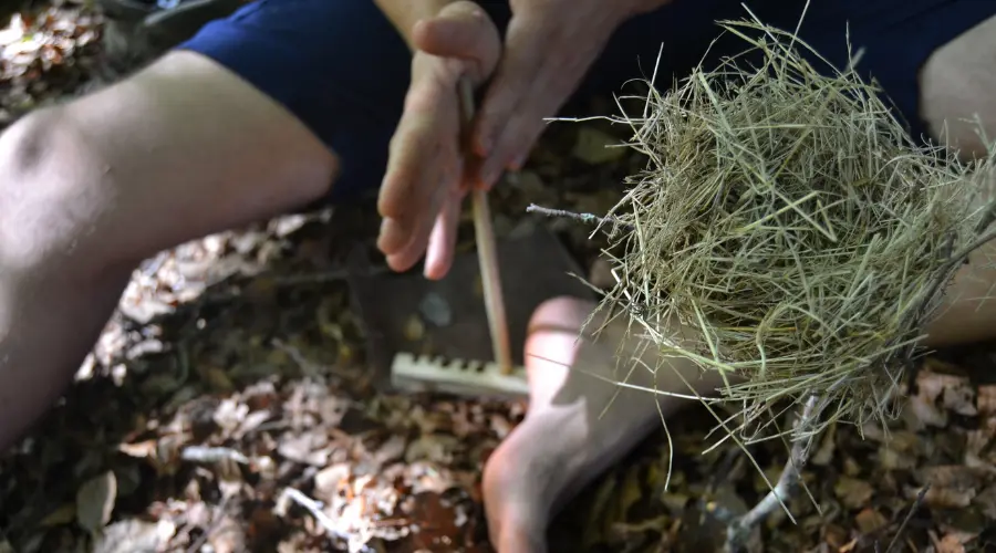 Accensione del fuoco con tecnica bushcraft e metodi di survival indigeno primitivo nel bosco