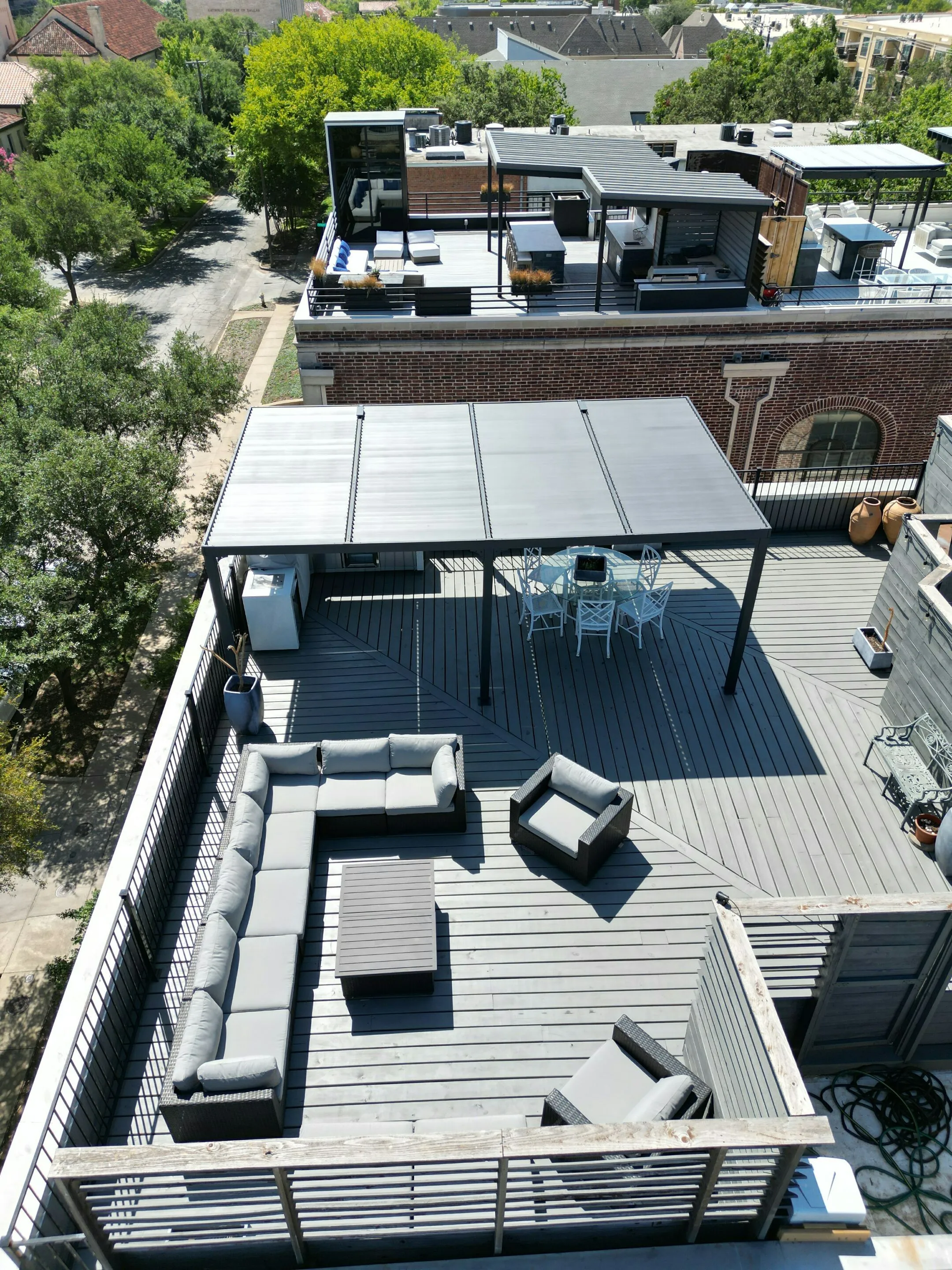Large residential rooftop deck with lounge seating and pergola on flat roof in Oak Lawn, Dallas