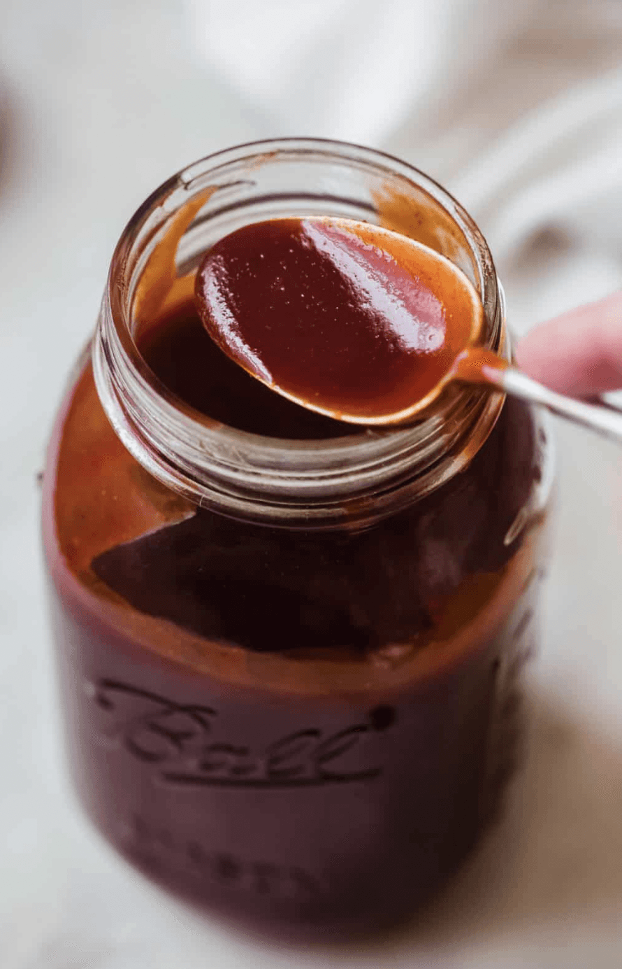 A gourmet plate featuring a golden-brown, breaded chicken cordon bleu or roulade, sliced to reveal a yellow filling, served with a creamy sauce, roasted potato wedges, and a side of fresh salad greens on a wooden table.