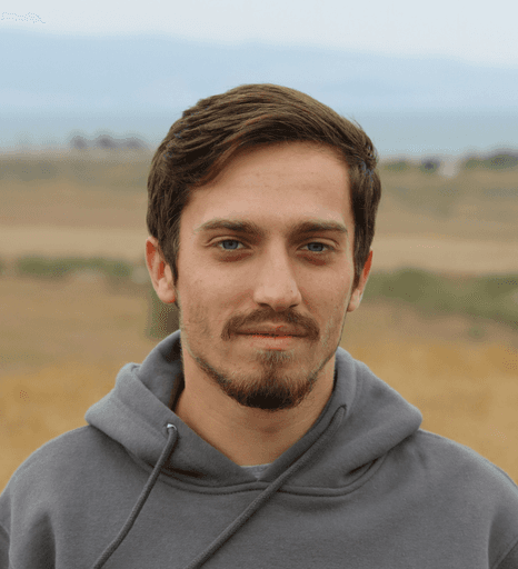 man in gray hoodie standing on field during daytime