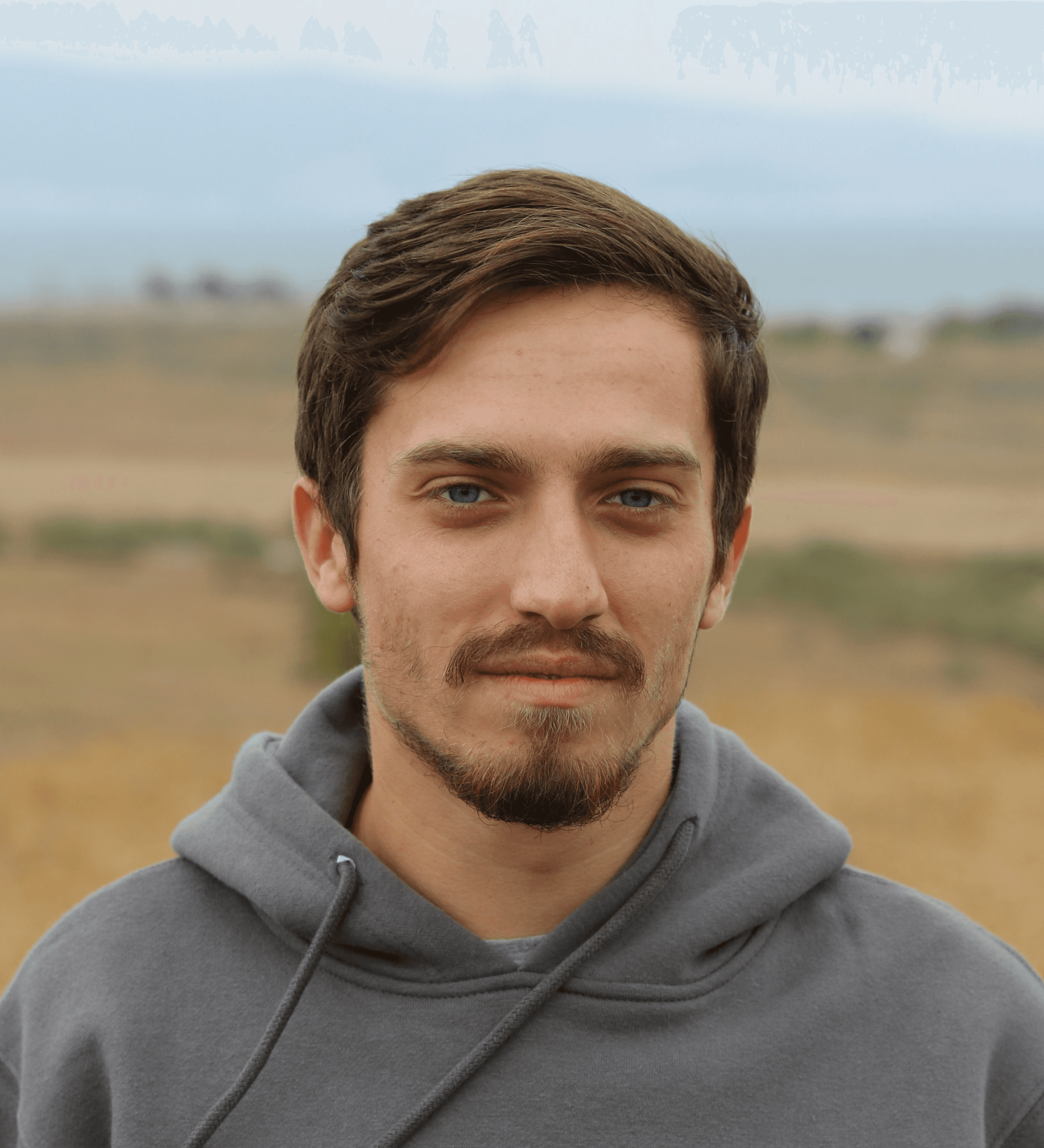 man in gray hoodie standing on field during daytime