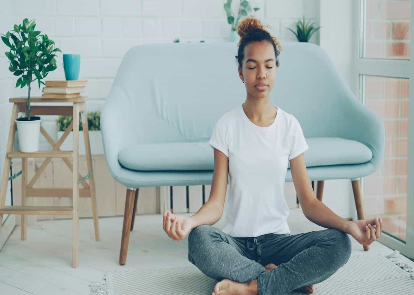 5 minute morning meditation - Woman meditating in her living room