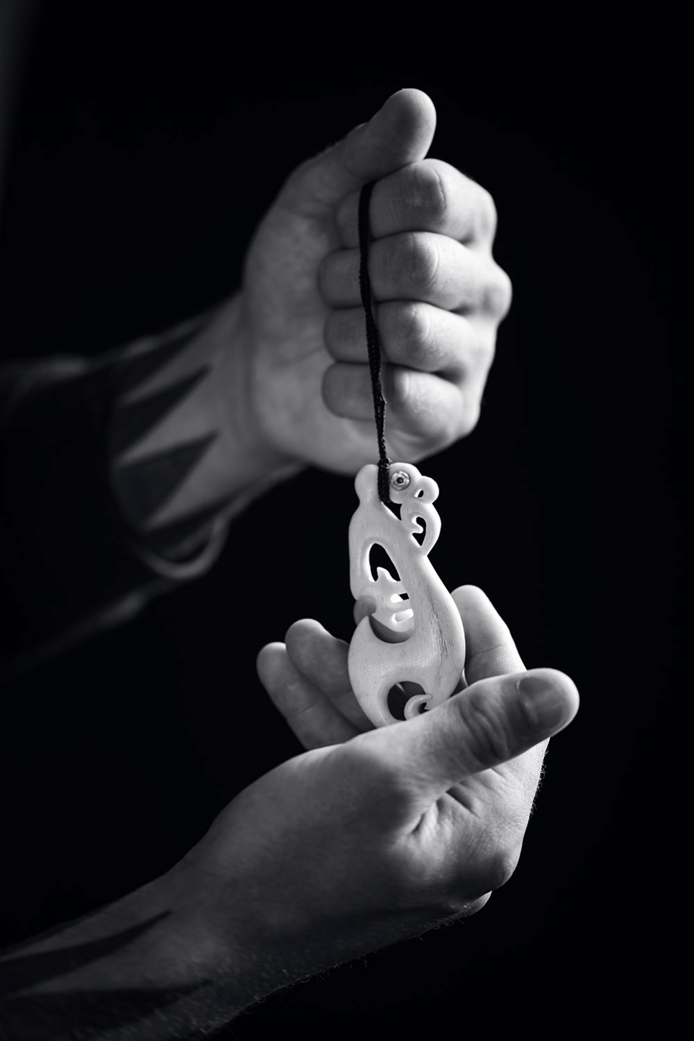 Man holding Maori bone carving for brand photoshoot by Kyttn Makerting consultant