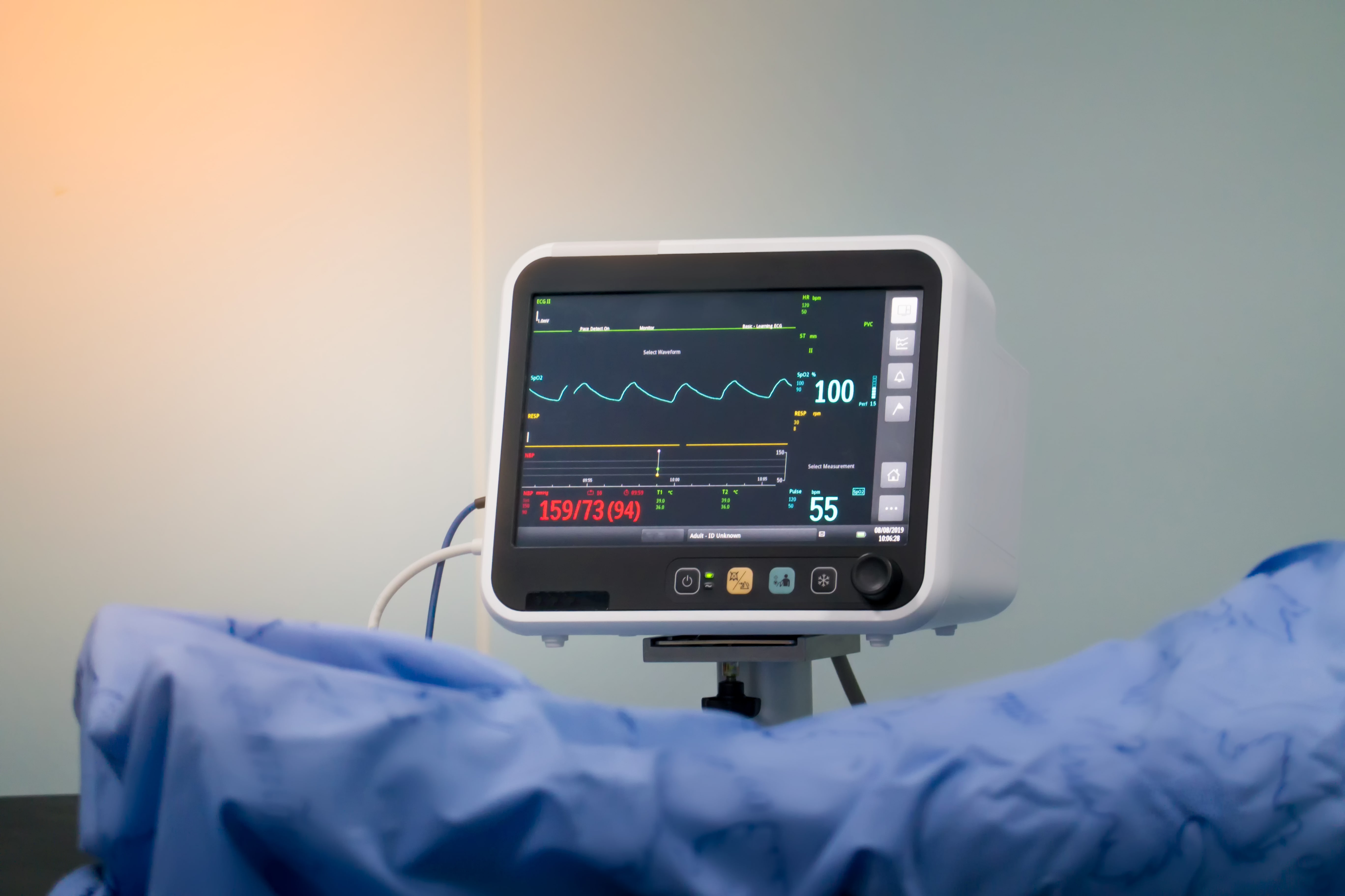 Close-up of a hospital patient monitor displaying vital signs such as heart rate, blood pressure, and oxygen saturation.