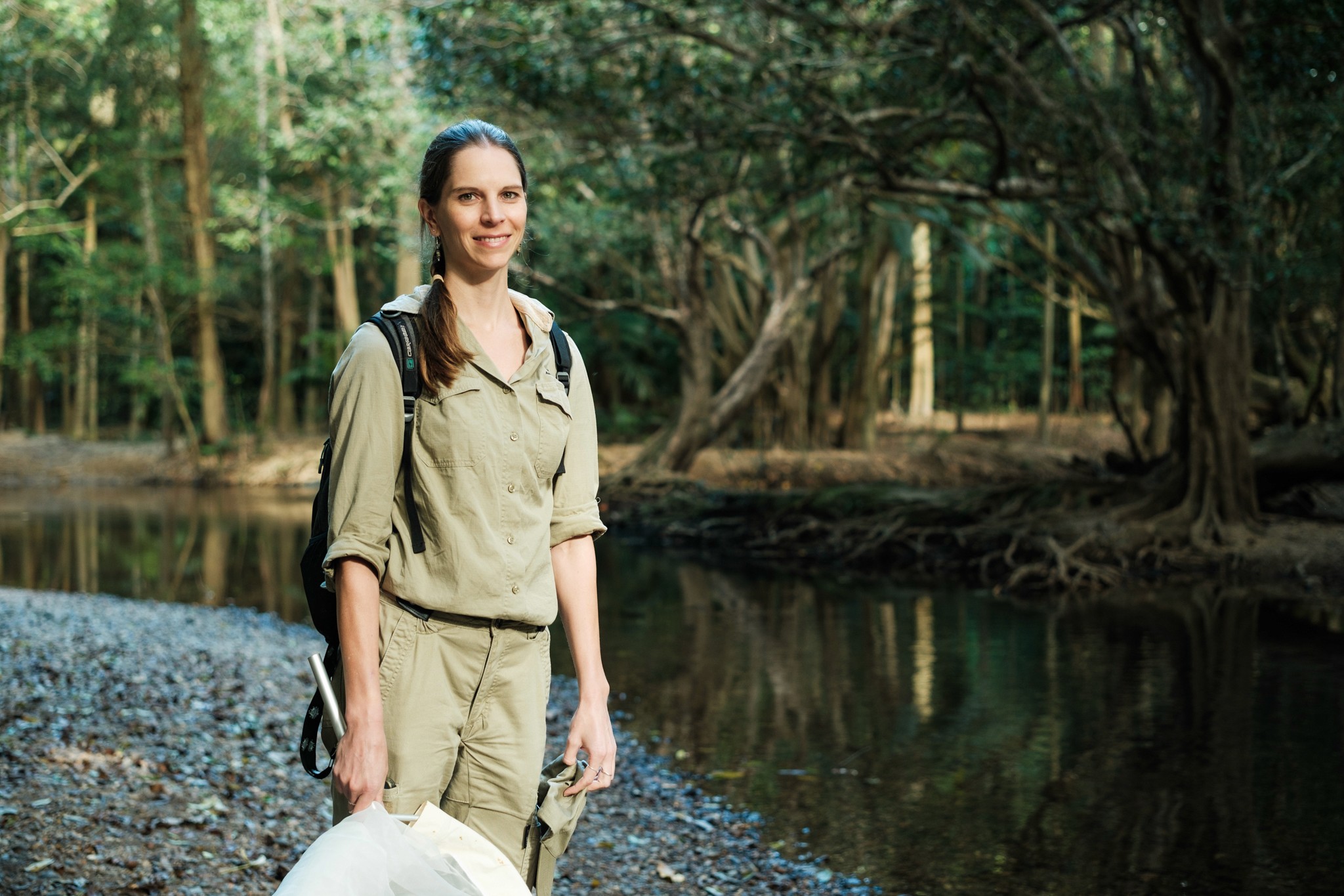 A woman stands next to a creek