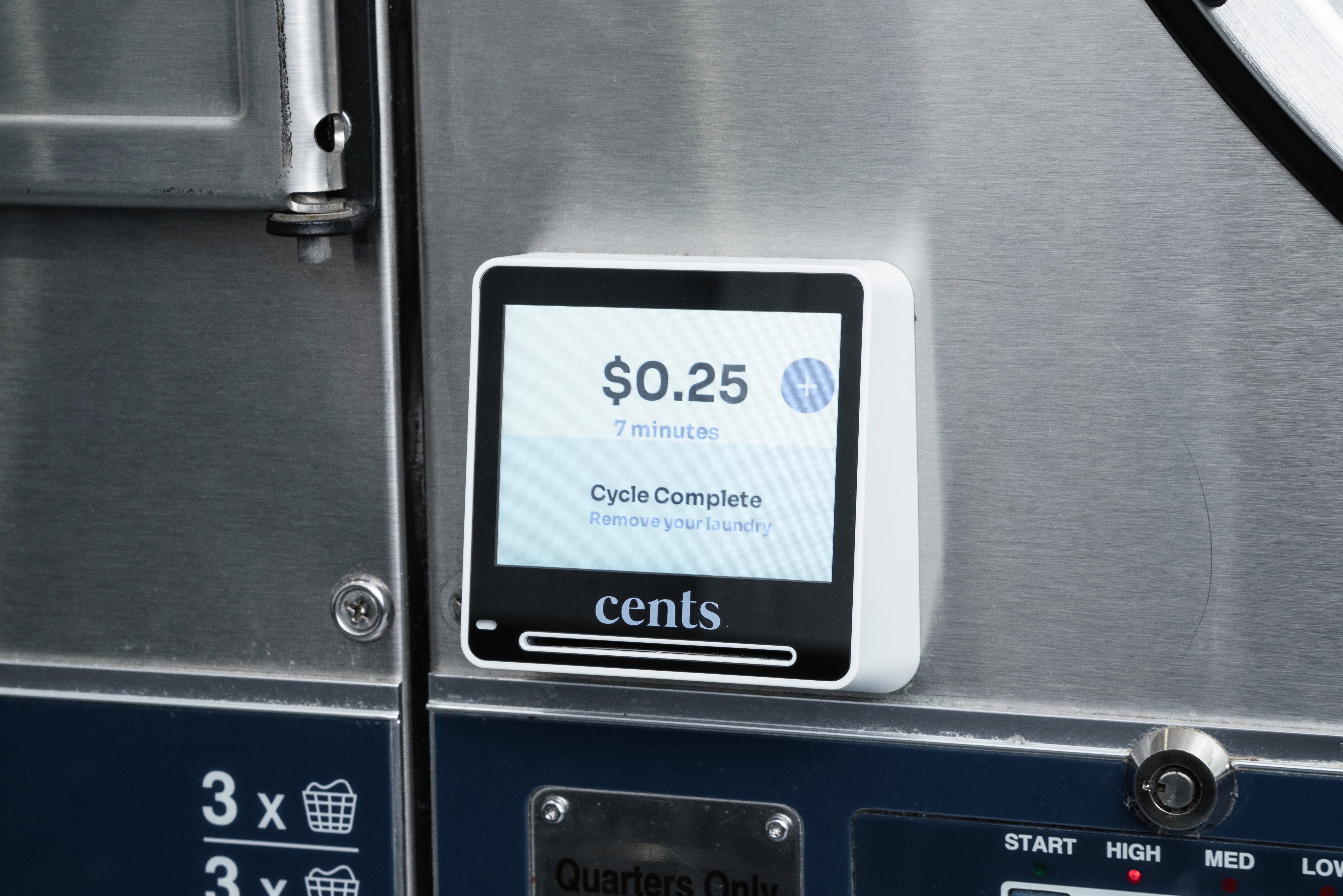 Close-up of a Cents payment terminal displaying laundry cycle time and cost on a commercial washer, showcasing modern laundromat technology for efficient payment and machine management.