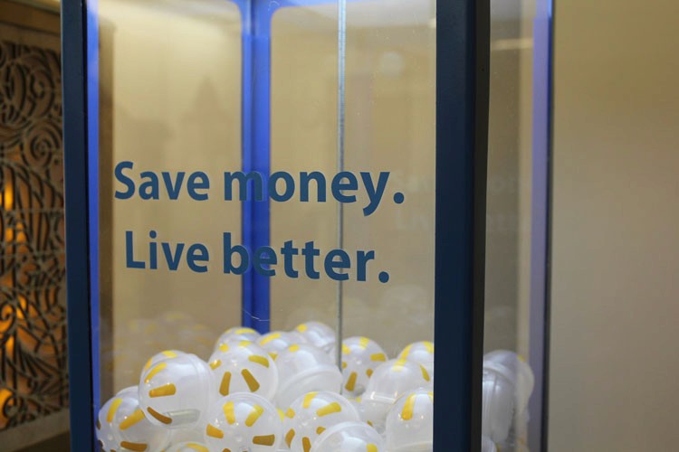 A photo of a vending machine with rubber balls in it and on the side glass the text: Save money. Live better.