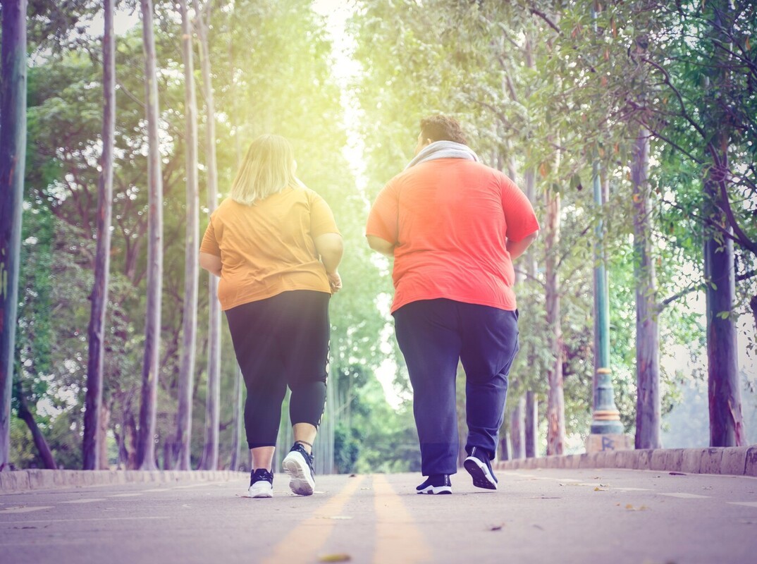 overweight couple going on an easy run to lose weight down a neighborhood road to ease into their weight loss plan