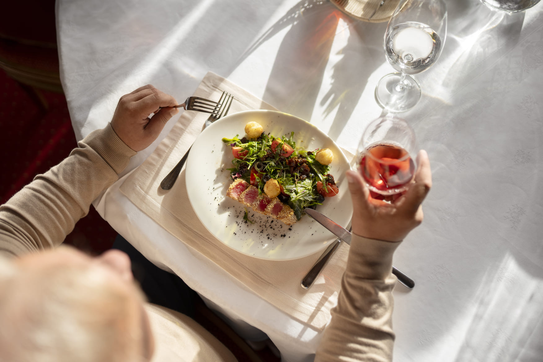 a person pouring sauce on a plate of food