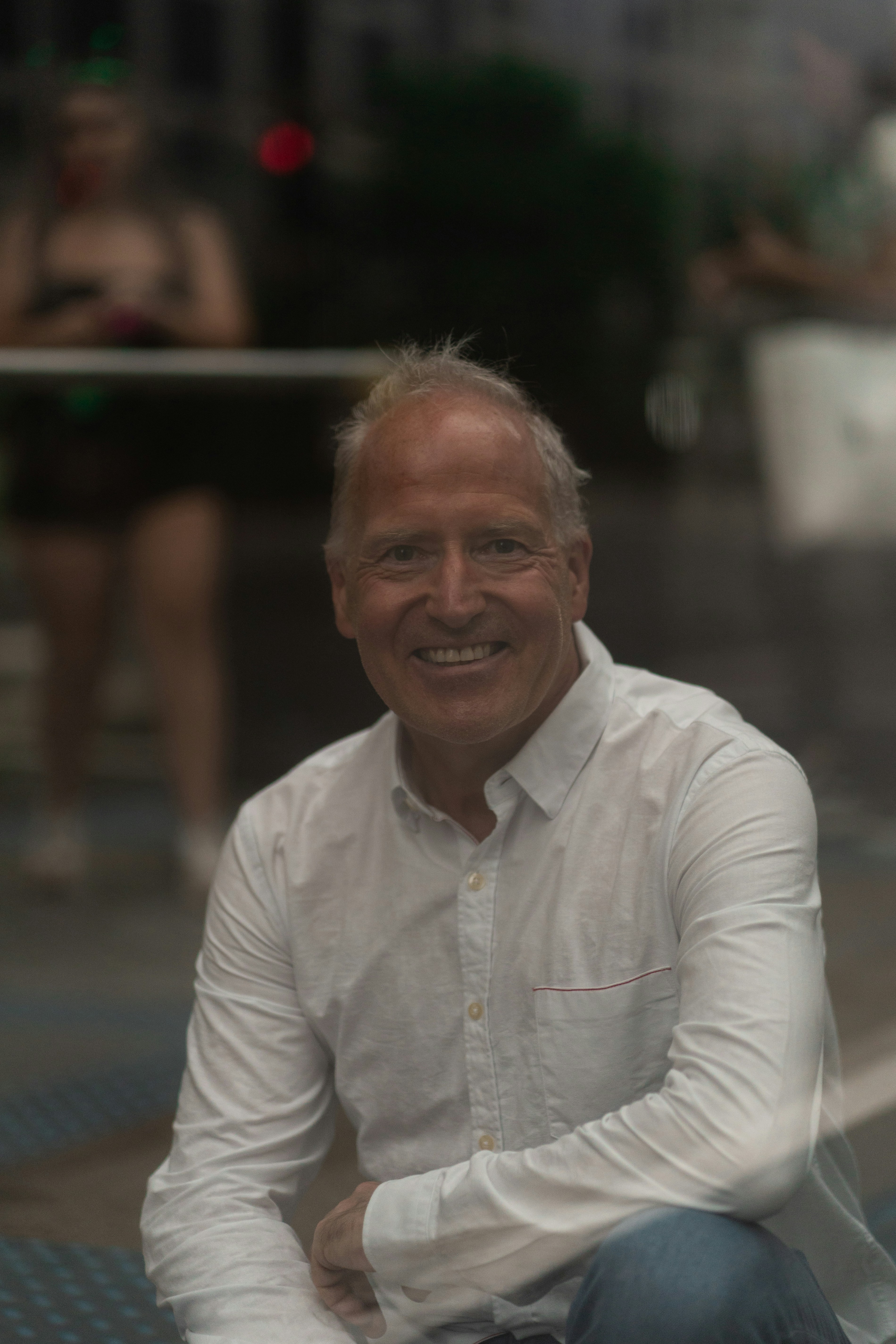 a man sitting on the ground in front of a building