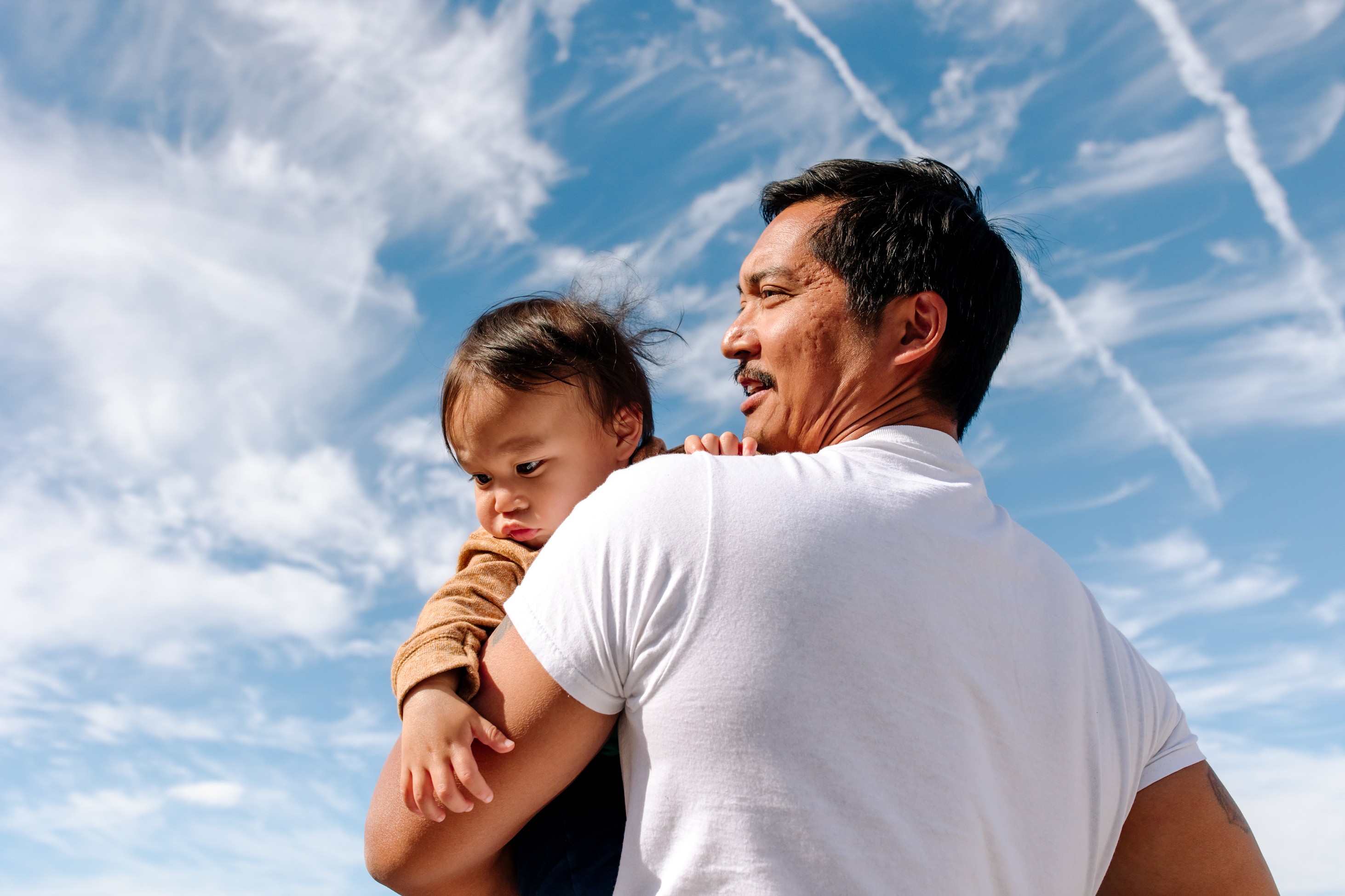 A man holds his child while he imagines what his future retirement can look like