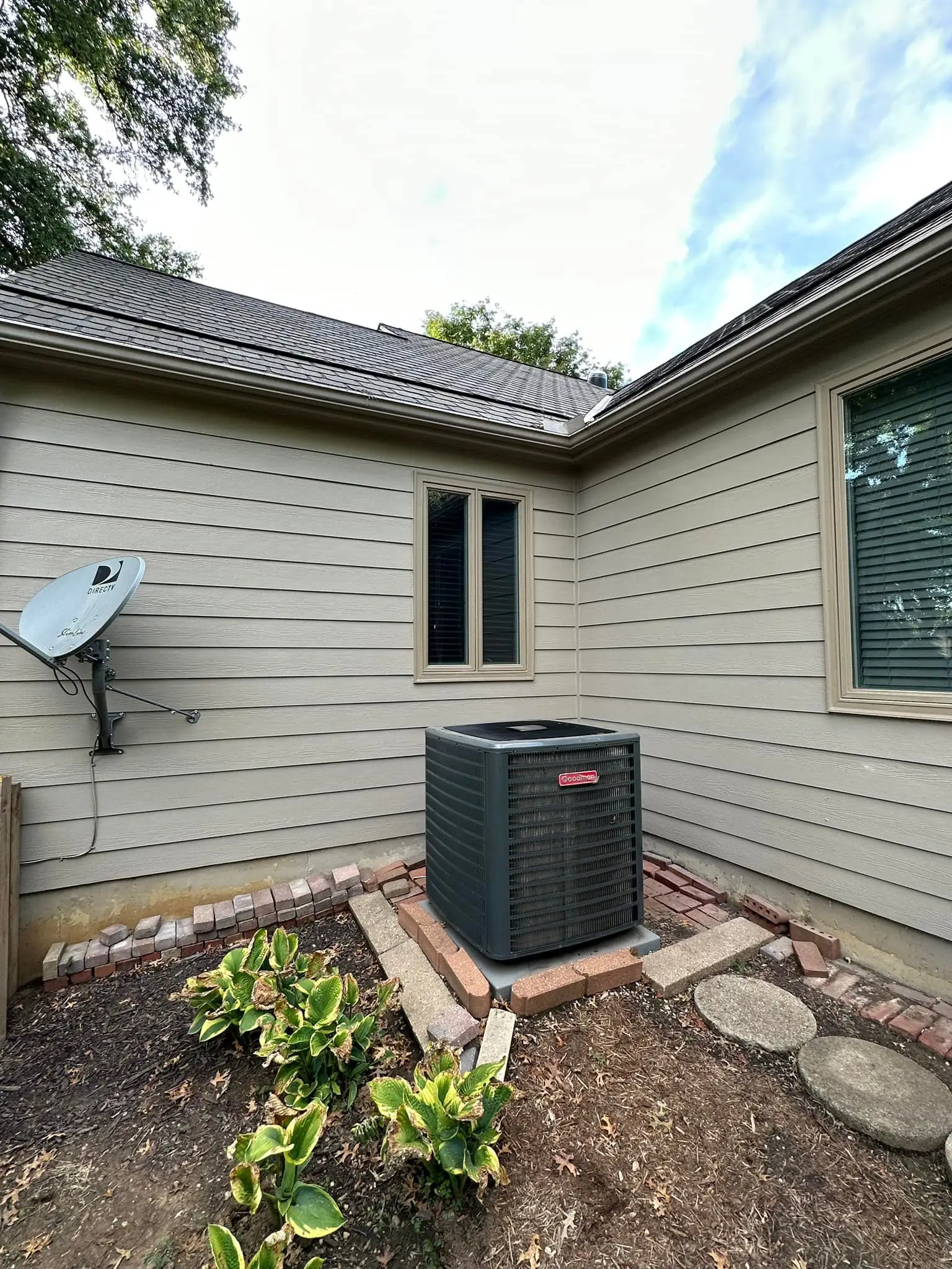 An image of the back of a tan house showing newly repaired wood rot.
