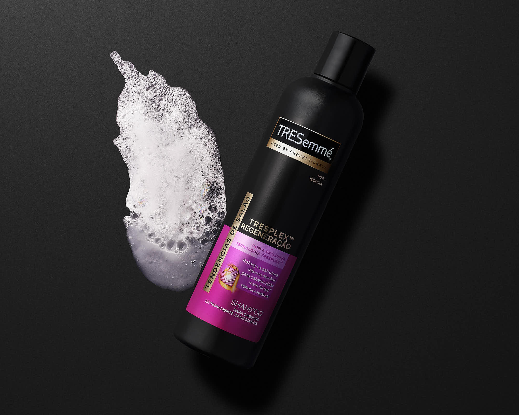 A dark background features a sleek black bottle of serum next to a dollop of creamy product.