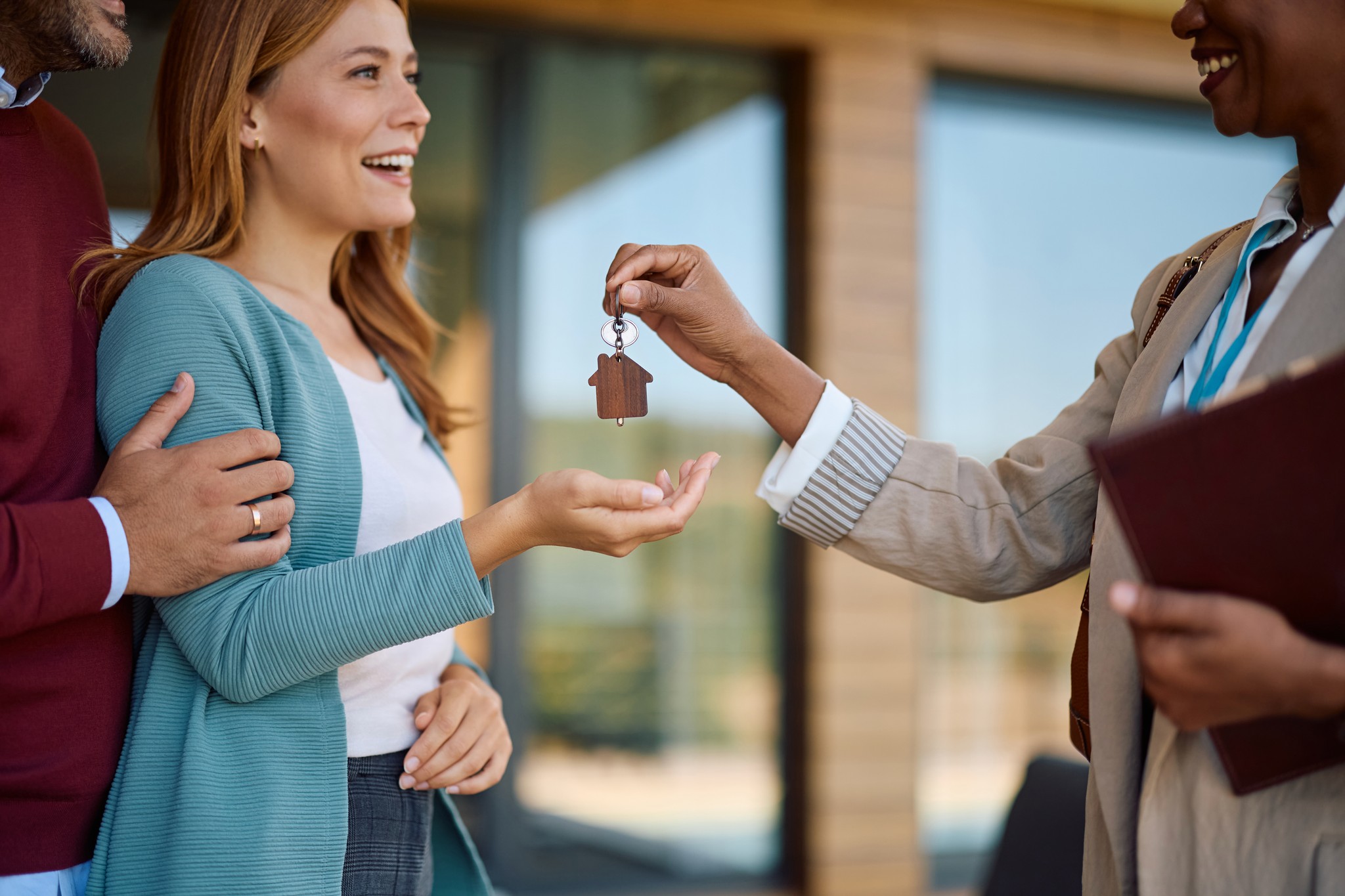 A winding road cuts through rocky terrain, surrounded by patches of green grass and illuminated by sunlight.