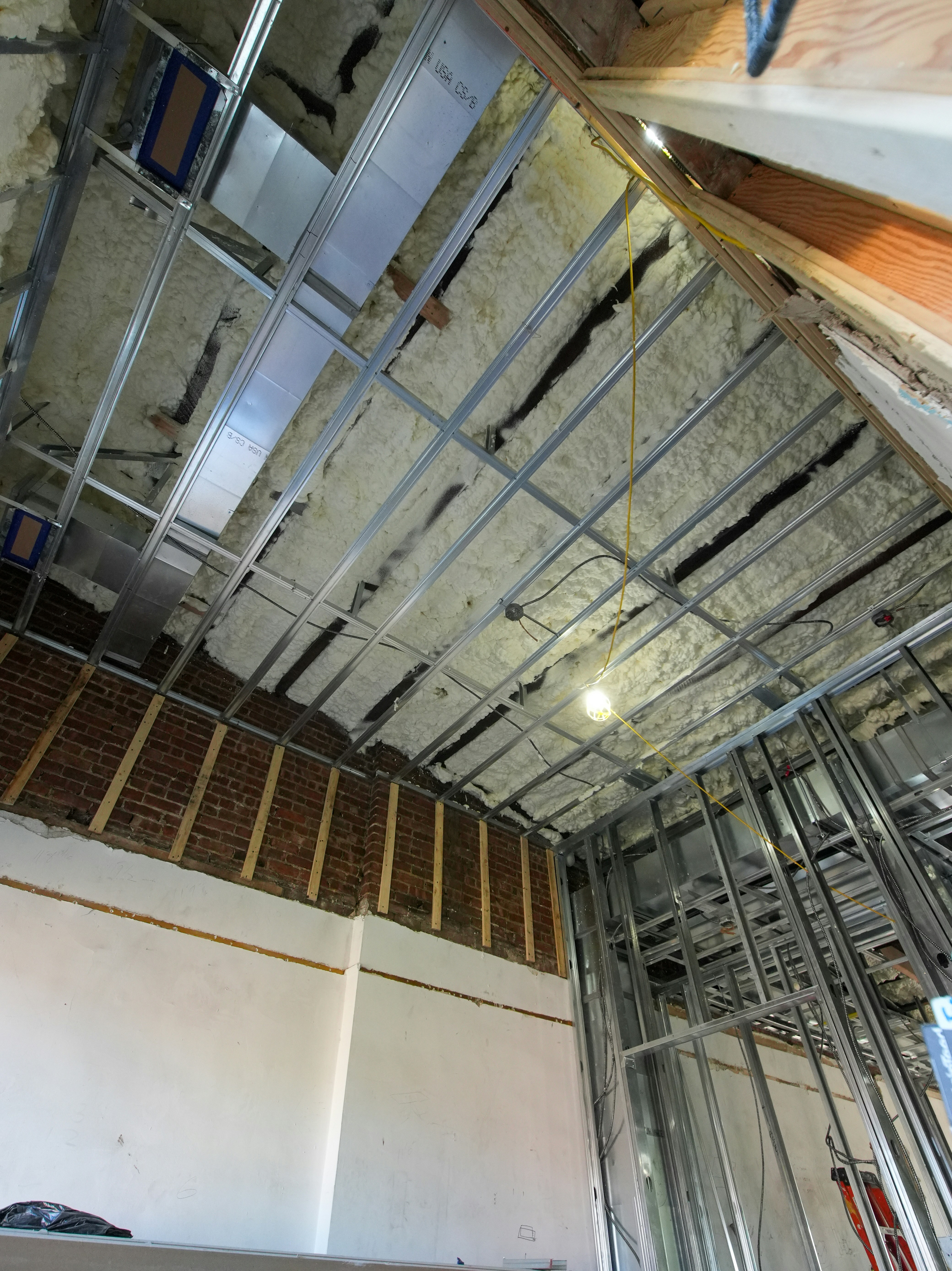 Building interior under construction with exposed framing and insulated ceiling