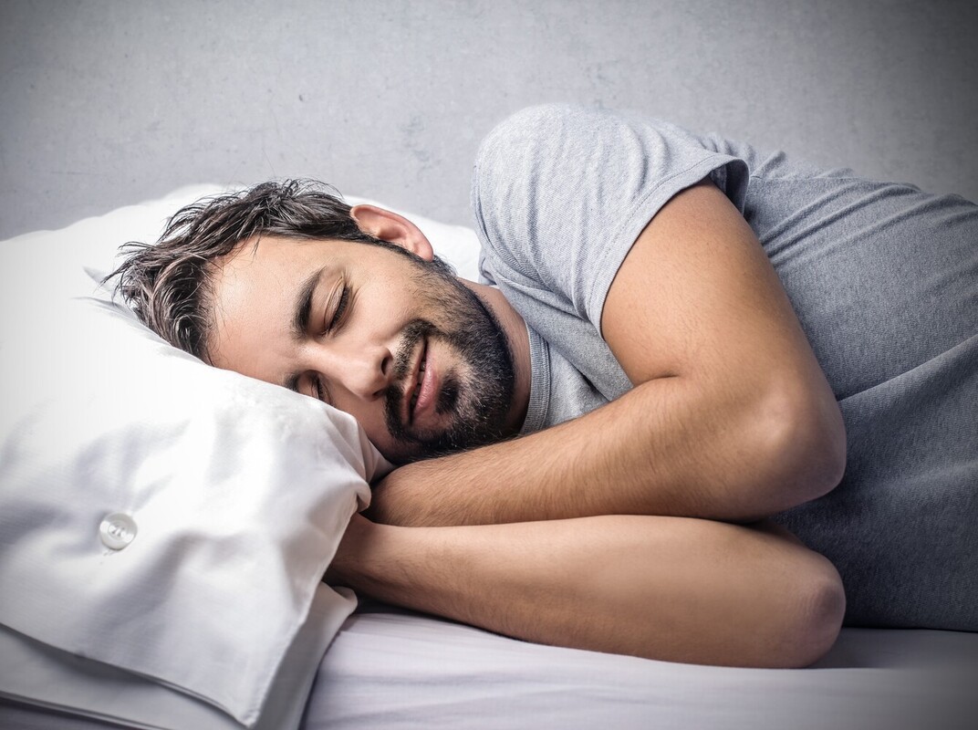 man sleeping peacefully after doing an exercise and steam room routine for weight loss and relaxation