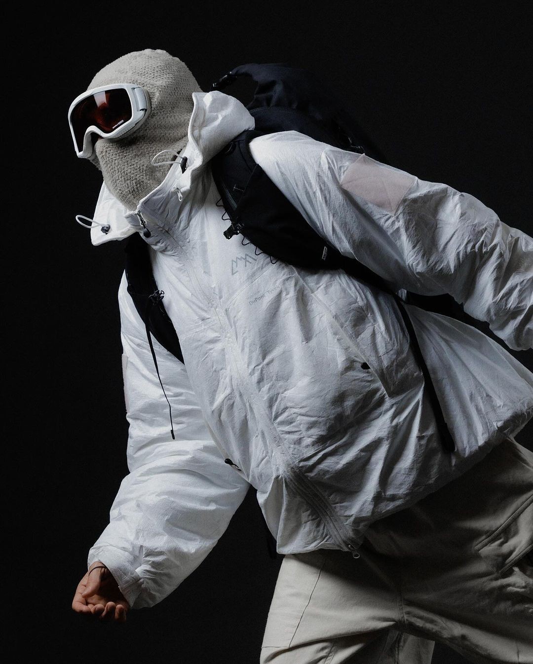 A person in a white suit and matching costume leaning back.