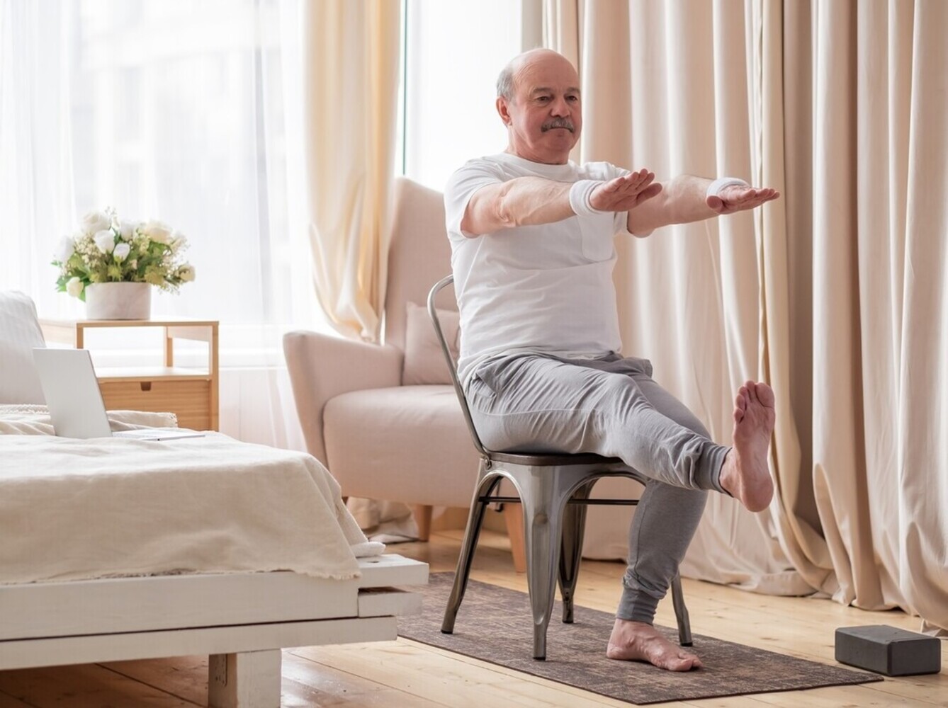 elderly man chair yoga for weight loss at home in his bedroom to help with fitness and mobility