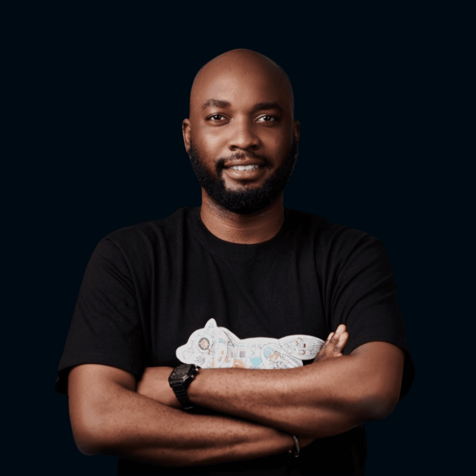 Asian man with glasses in a creative workspace, surrounded by colorful abstract art and stationery on a cluttered desk.