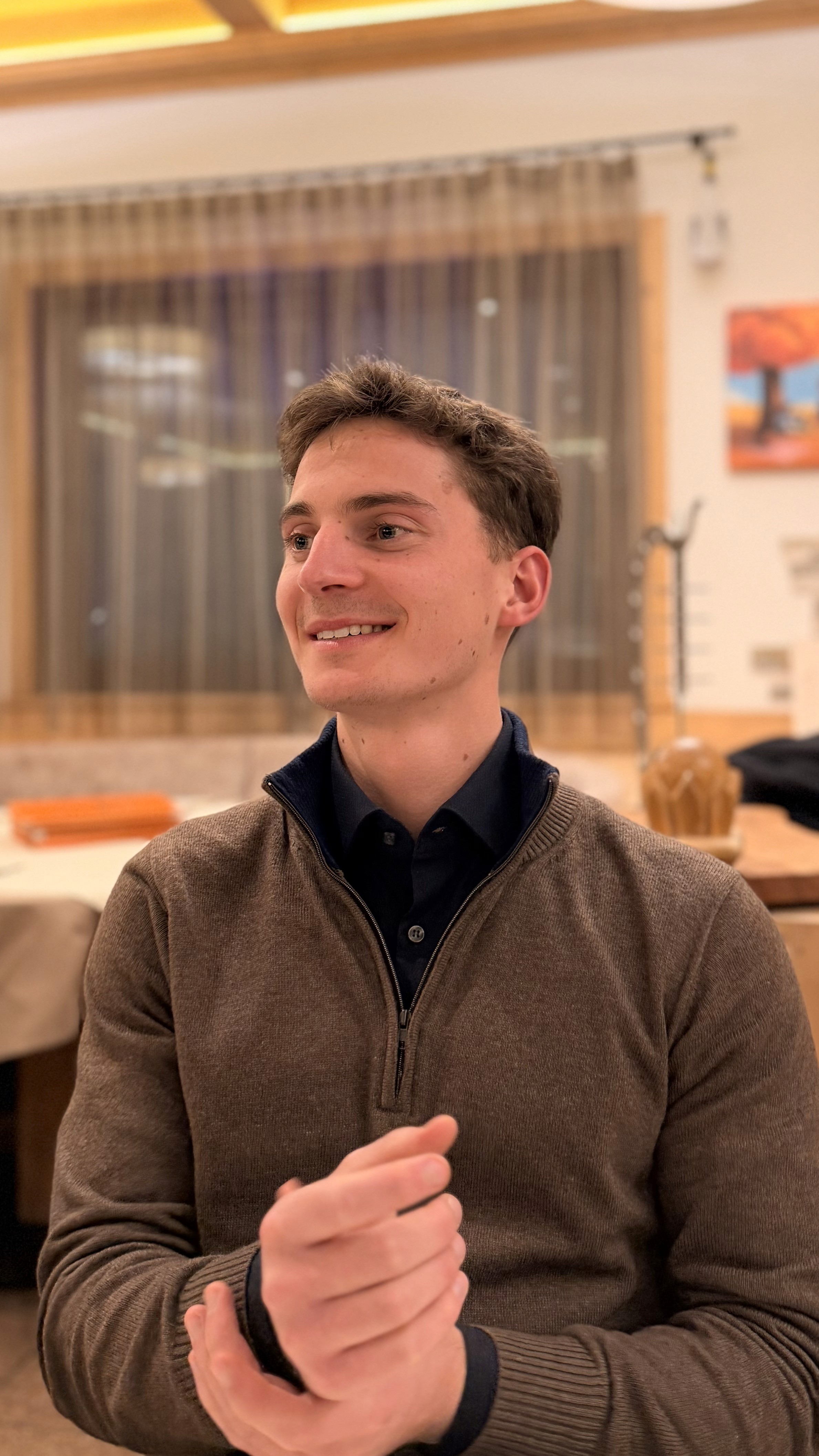 Portrait of a person in dark clothing speaking on a phone