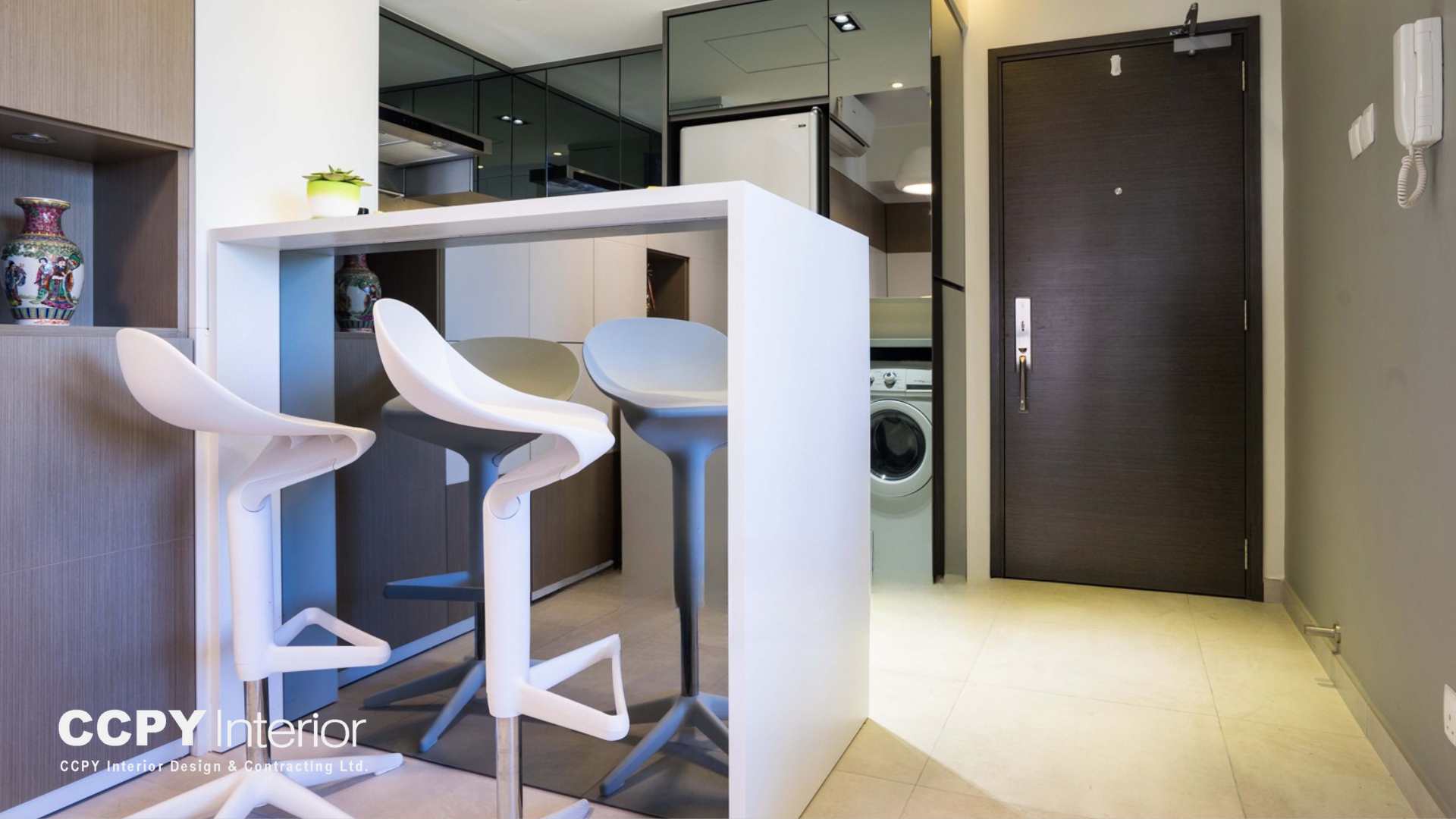 Symmetrical open-plan view of a Mount Pavilia residence showcasing a marble breakfast bar and sophisticated deep blue cabinetry designed by CCPY Interior.