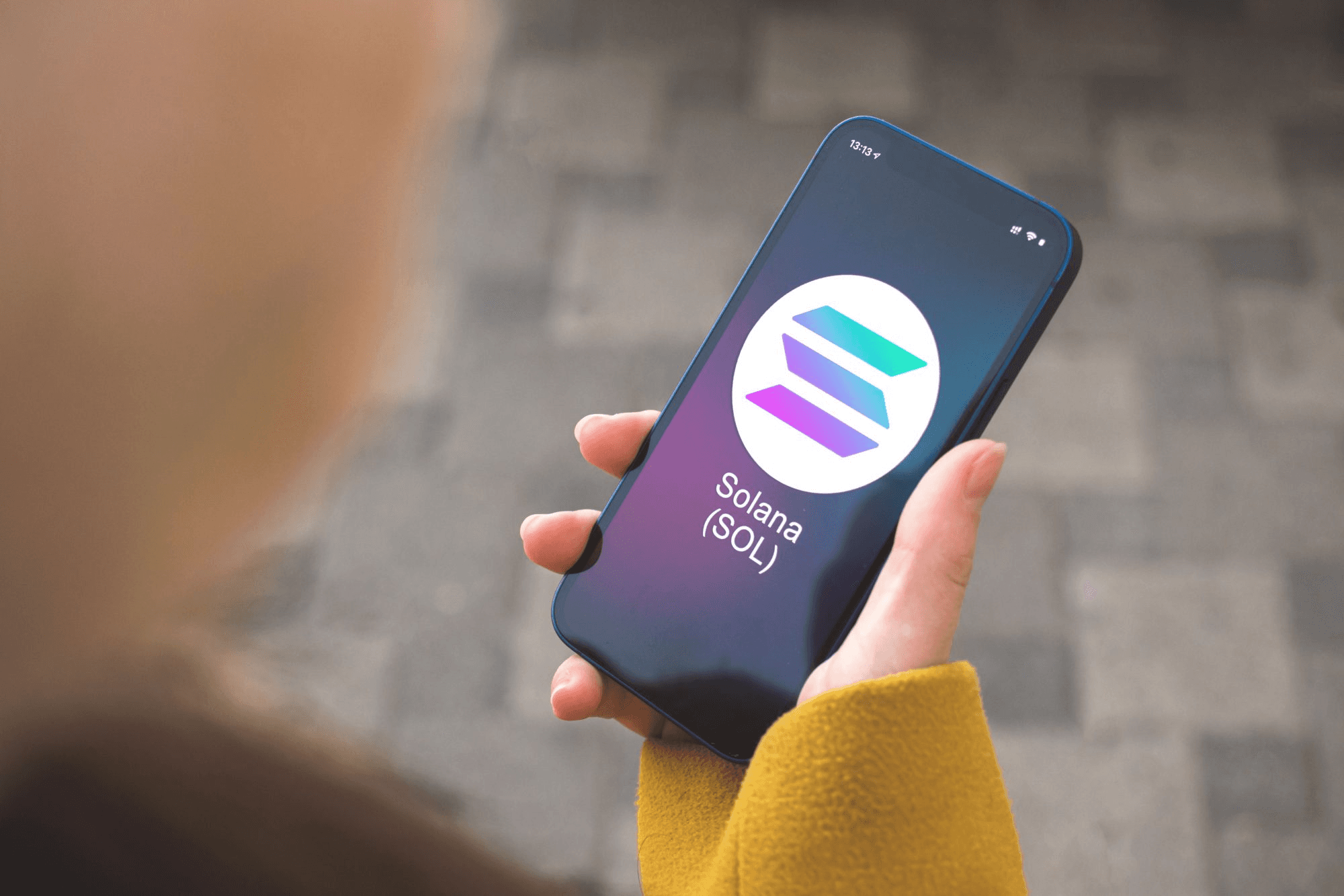 Person holding phone displaying Solana app - How to Buy Memecoins on Solana