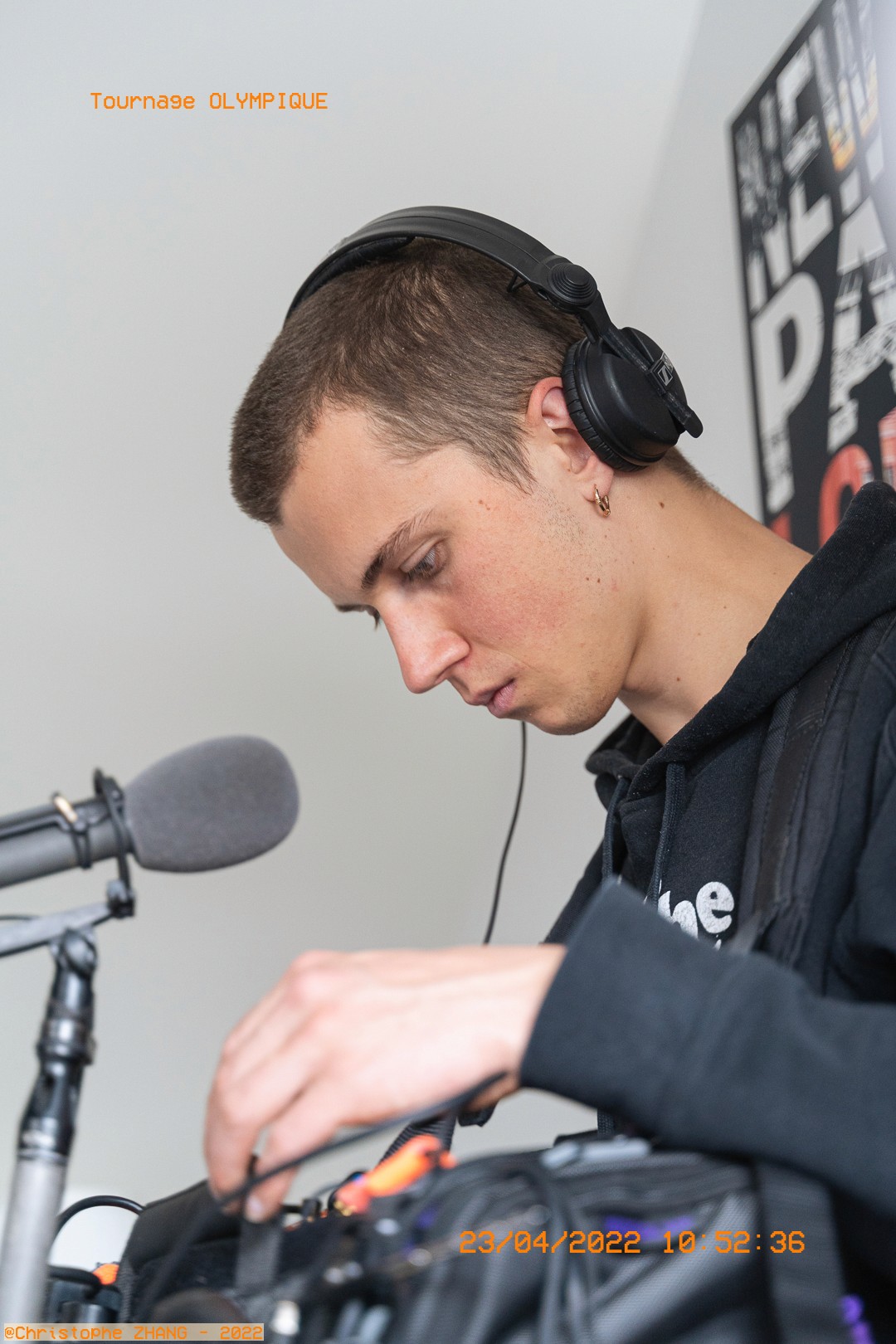 Ingénieur son concentré, casque sur les oreilles, réglant une console audio.