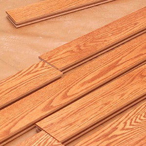 橡木色實木地板安裝工程,展示木地板鎖扣拼接及防潮底層鋪設,專業家居裝修地板工程。