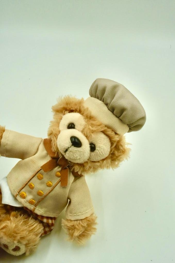 A stuffed bear wearing a chef outfit

Description automatically generated