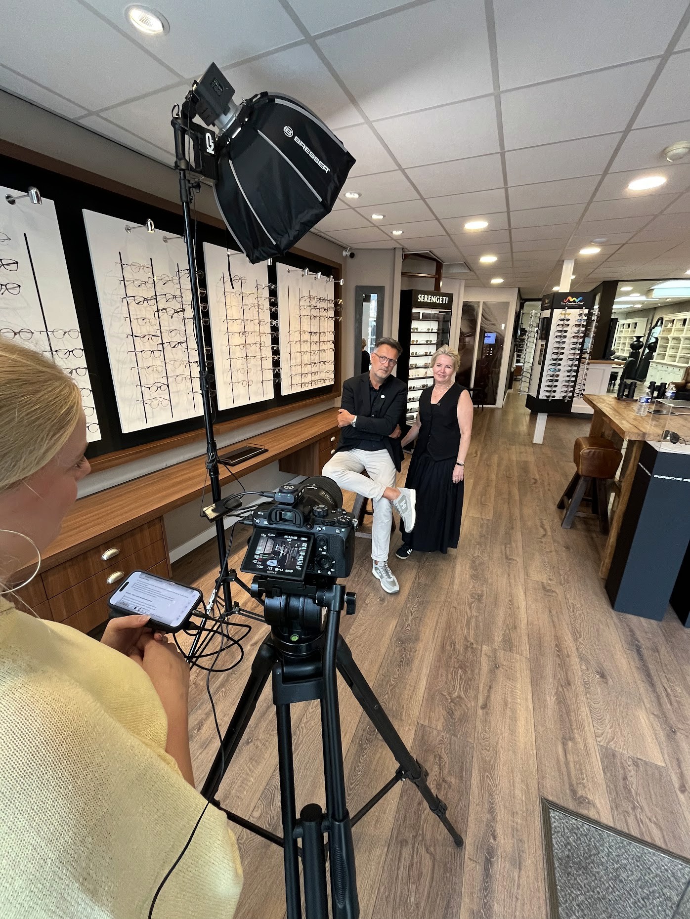 man writing beside wall with car photos