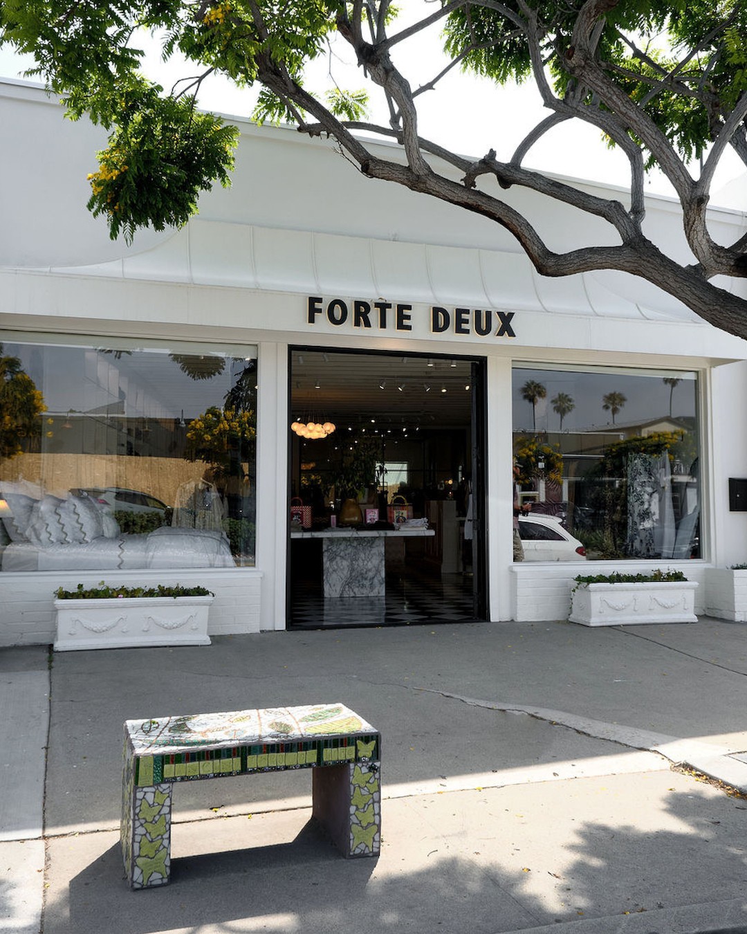 Forte Deux fashion boutique storefront with minimalist backlit exterior signage mounted on white building façade.
