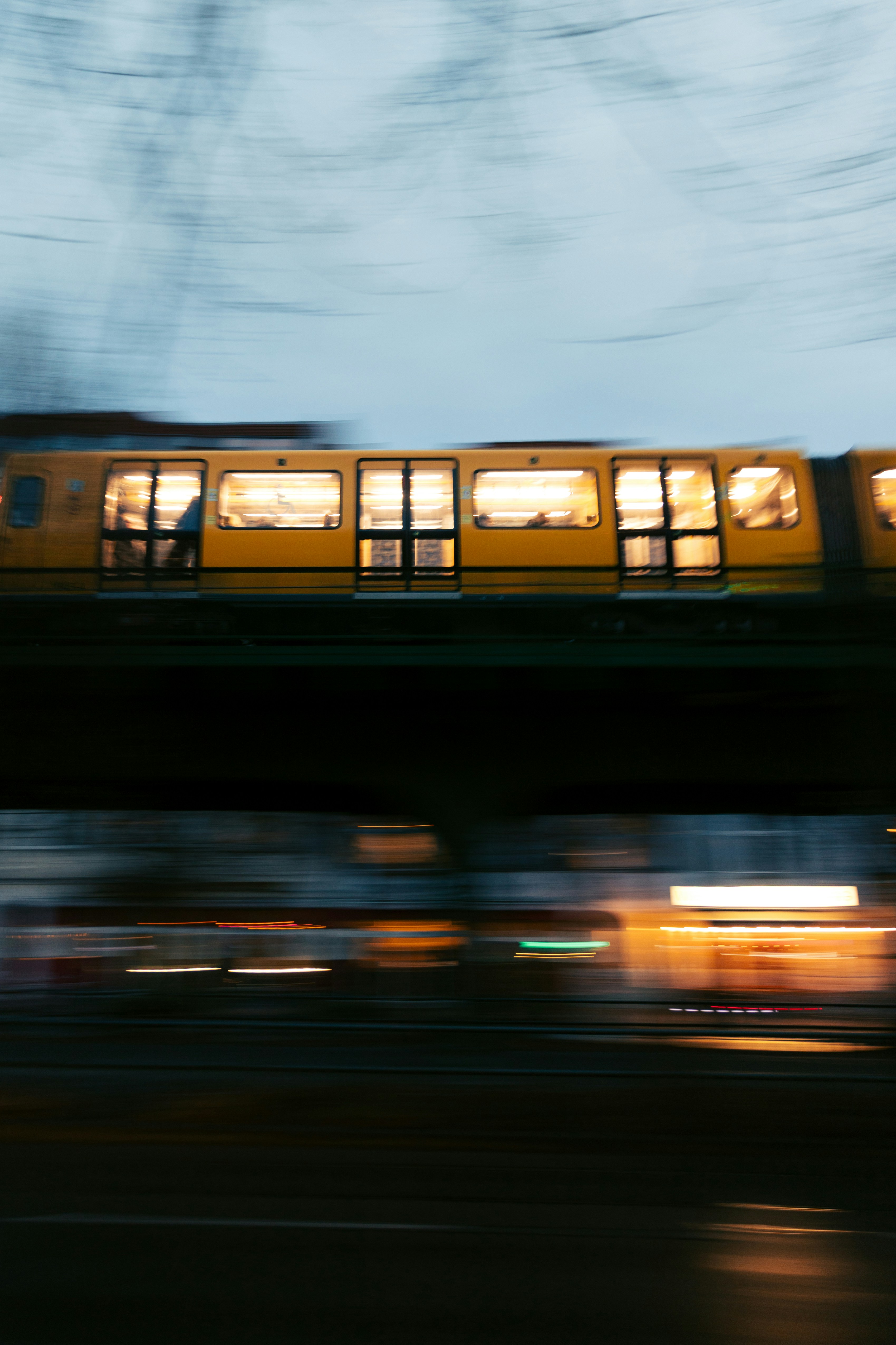 Blurred yellow train moving on elevated track at night