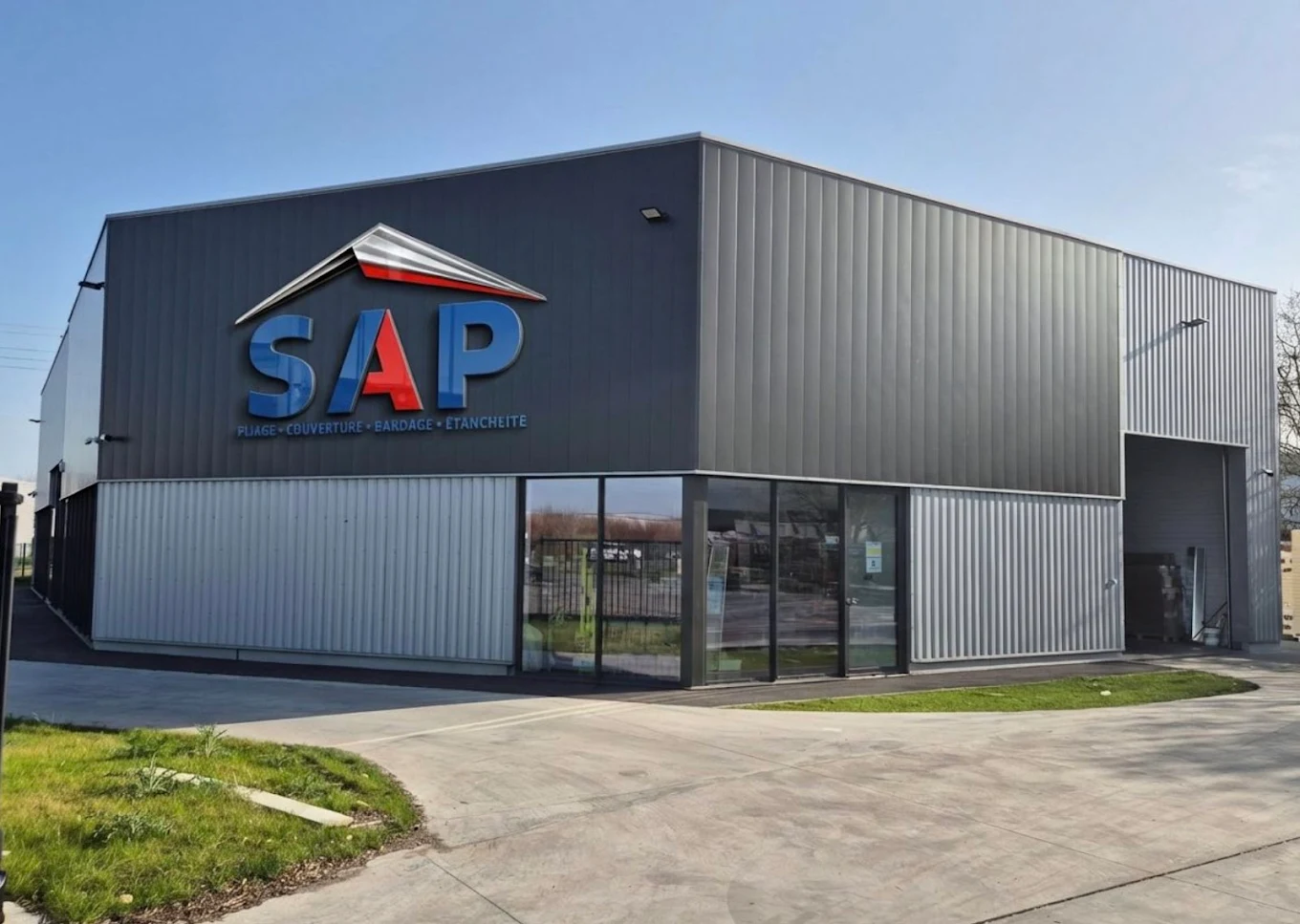Young Asian man with dark hair and stubble, wearing a gray t-shirt in a softly lit room with a blurred background.