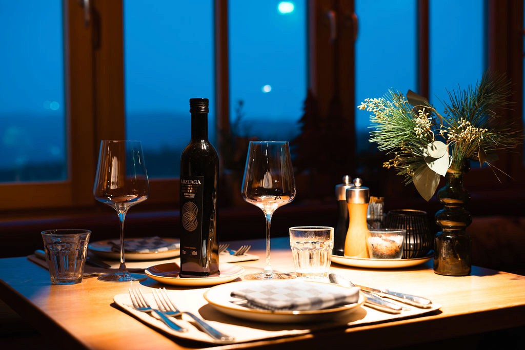 Warmtoniges Außenlicht ergänzt die winterliche Umgebung und verleiht Fassade und Terrasse eine einladende und stimmungsvolle Wirkung im Außenbereich.