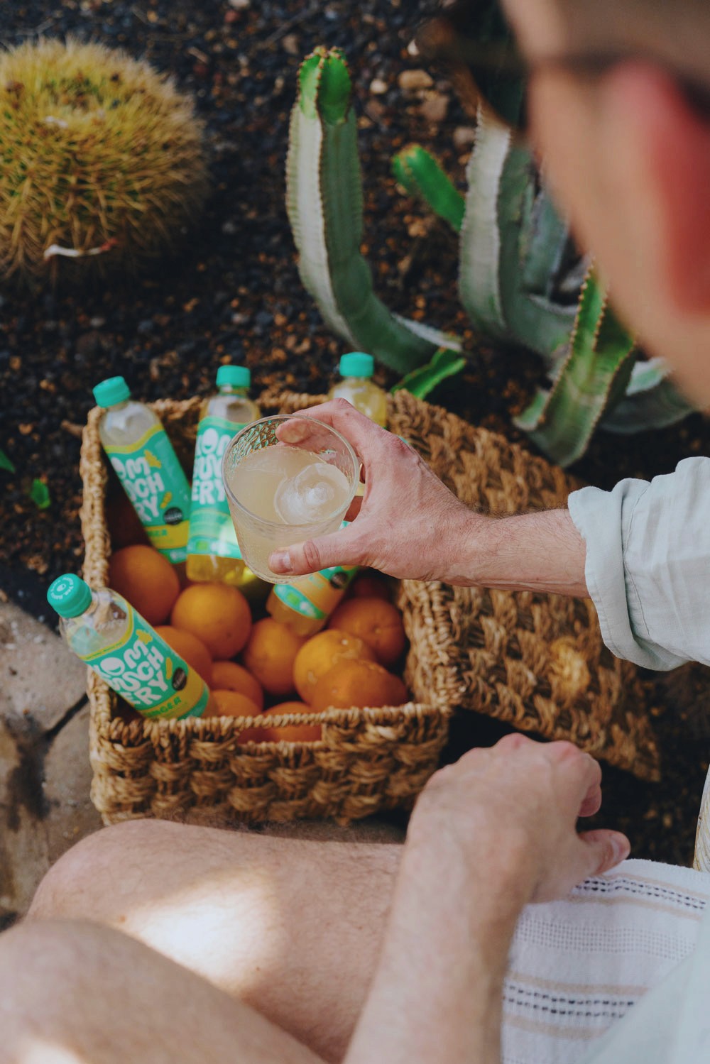 Korb mit Orangen und Kombuchery Mann mit Glas in der Hand